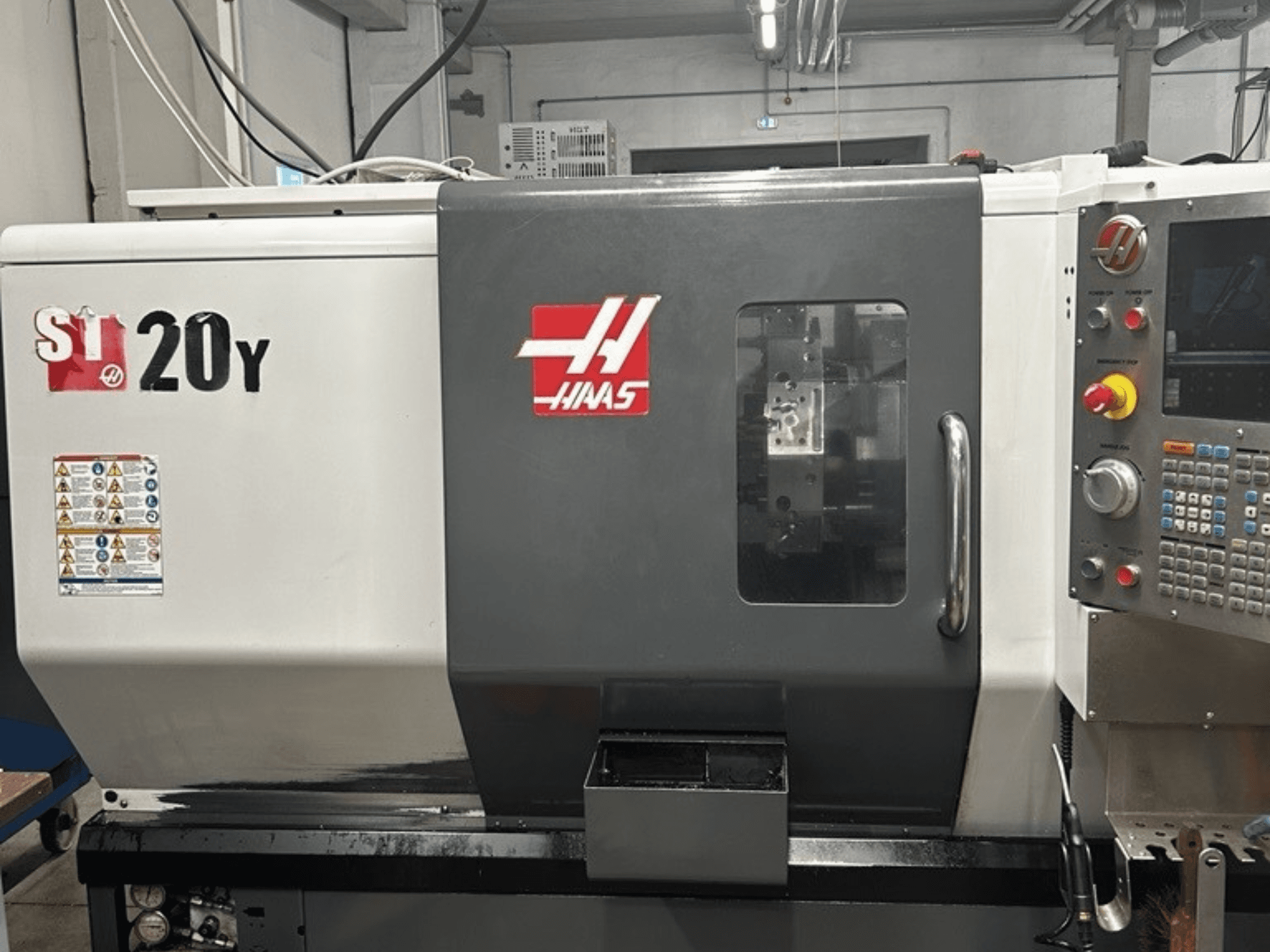 Haas ST-20Y CNC-tööpink, esivaade, kus on näidatud juhtpaneel, ohutussildid ja tööaken.