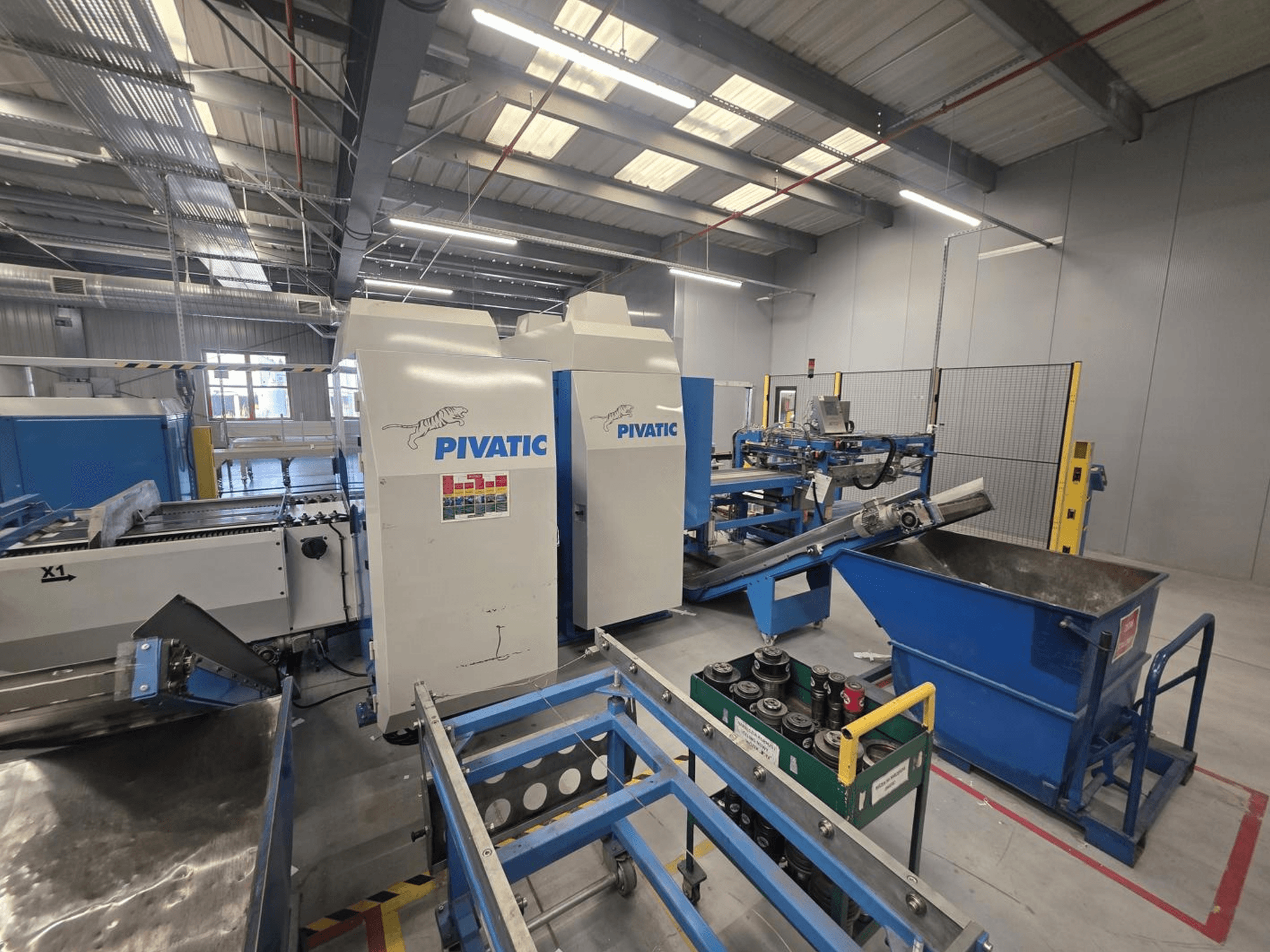 CNC-stantsimismasin Pivatic PCC80-e TT HT, esivaade, millel on näha tööseadistus, konveier ja jäätmekast.