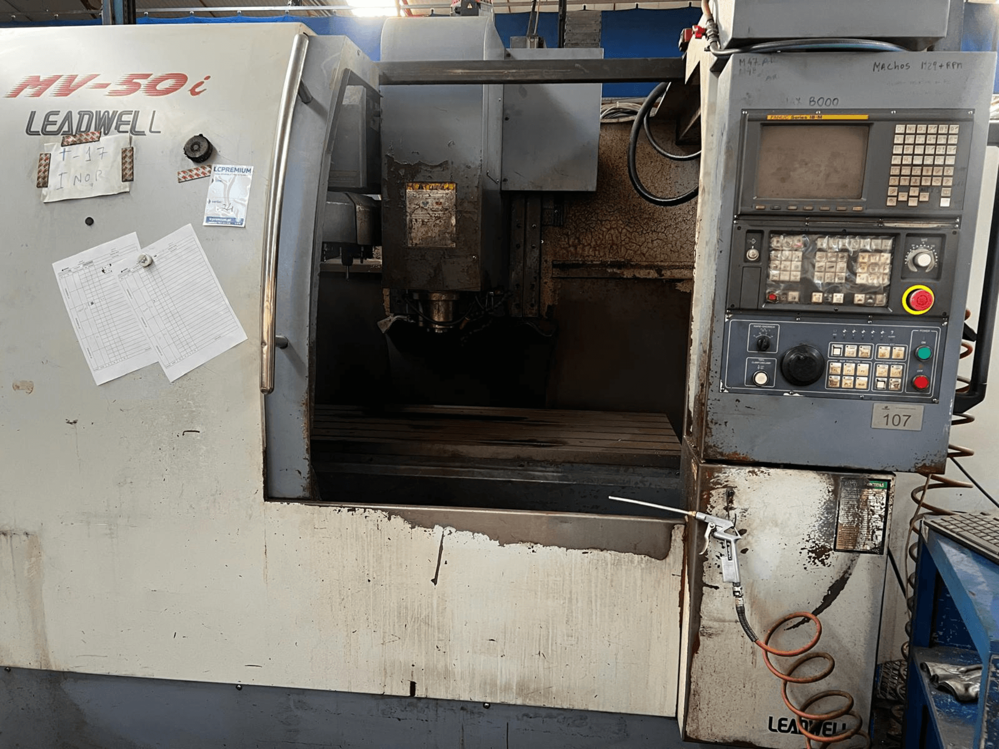 Leadwell MV-50i vertikaalne töötlemiskeskus, vaade eest, millel on näha juhtpaneel, spindli piirkond ja kulumisjälgedega tööpink.