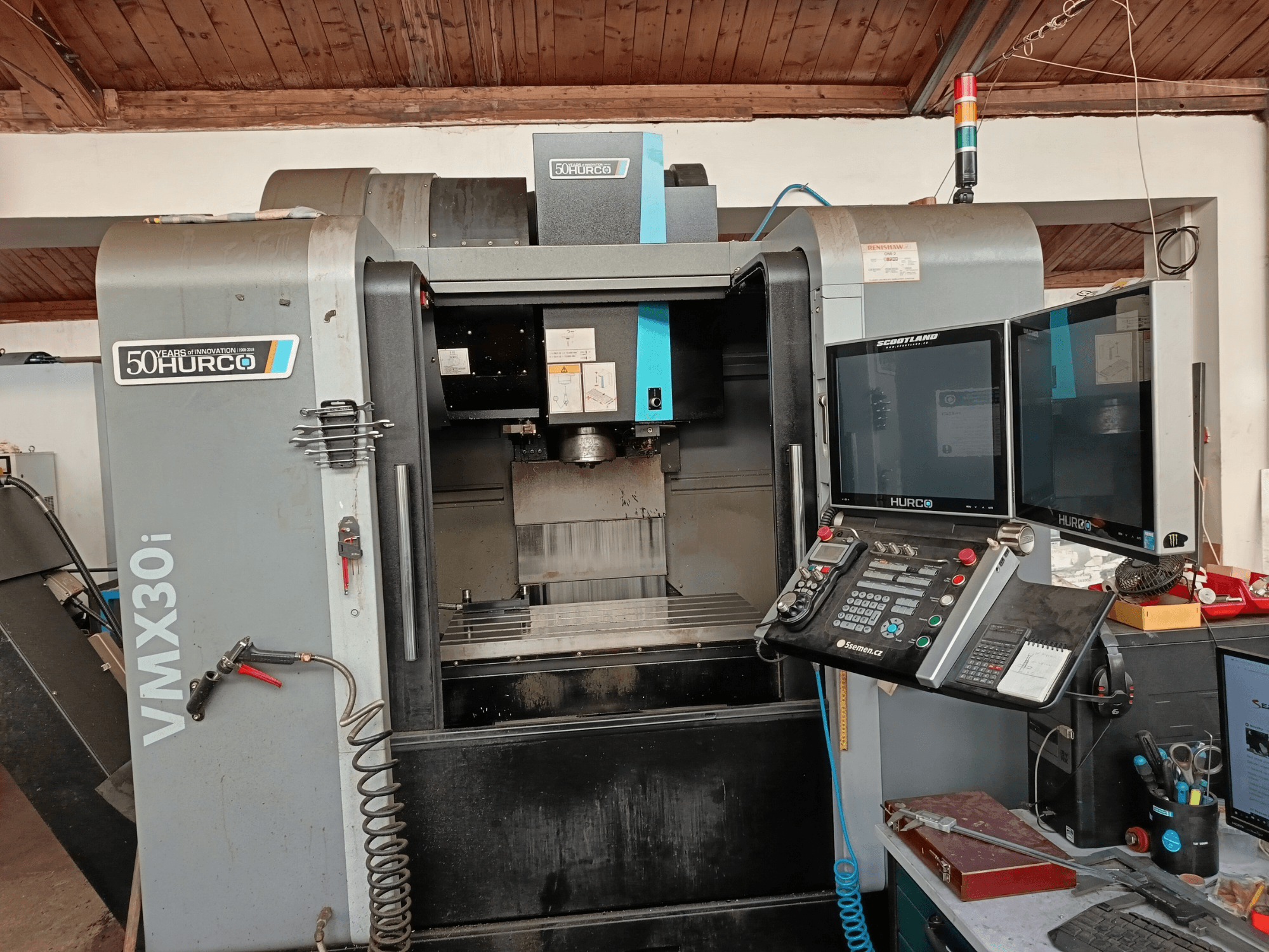 Hurco VMX30i CNC-freesping eesvaates, millel on kaks monitori, juhtpaneel ja lisatud voolik.