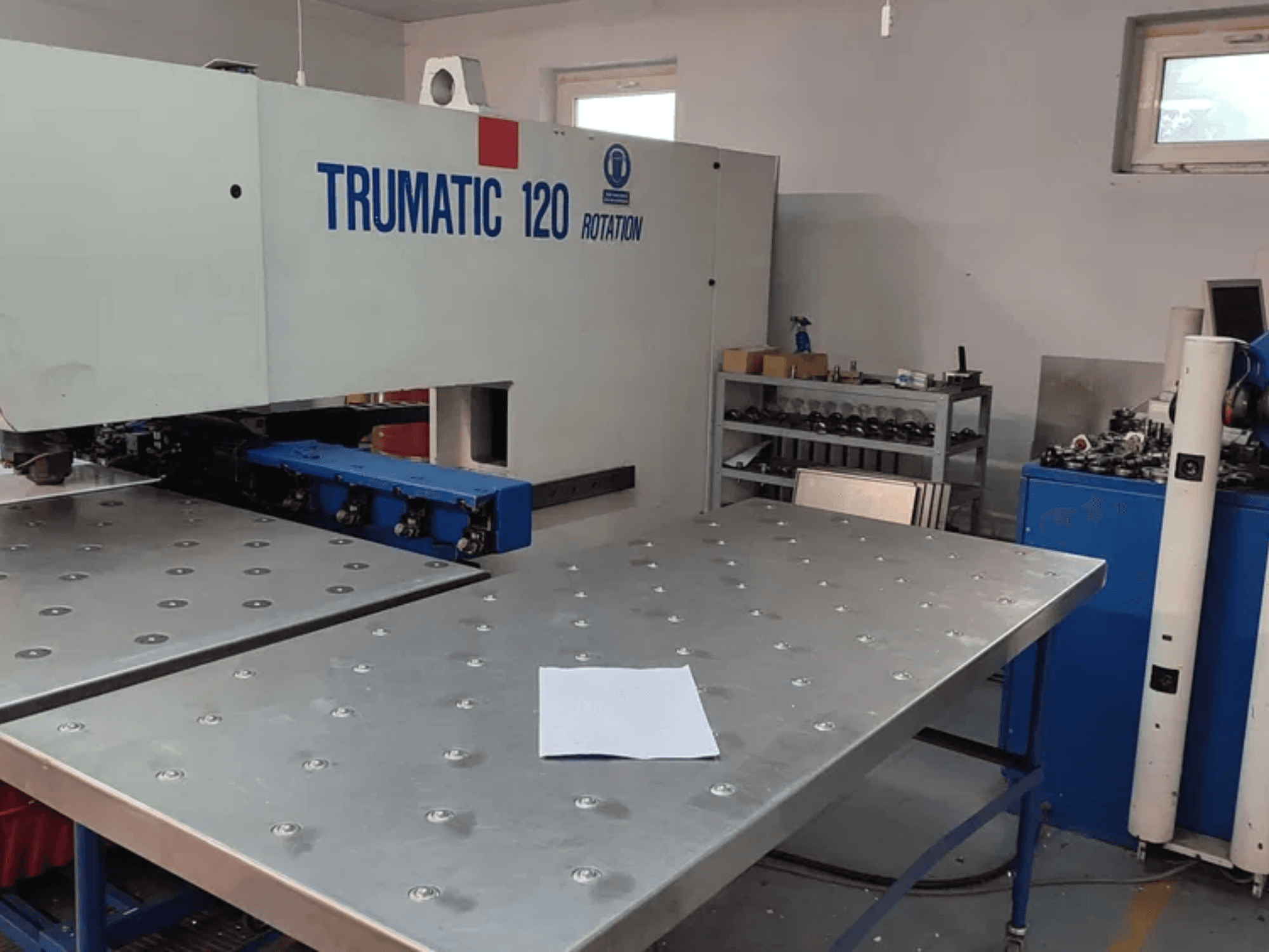 TRUMPF TRUMATIC 120R CNC-stantsimismasin esiplaanilt, millel on metallist stantsimislaud ja tühi leht.