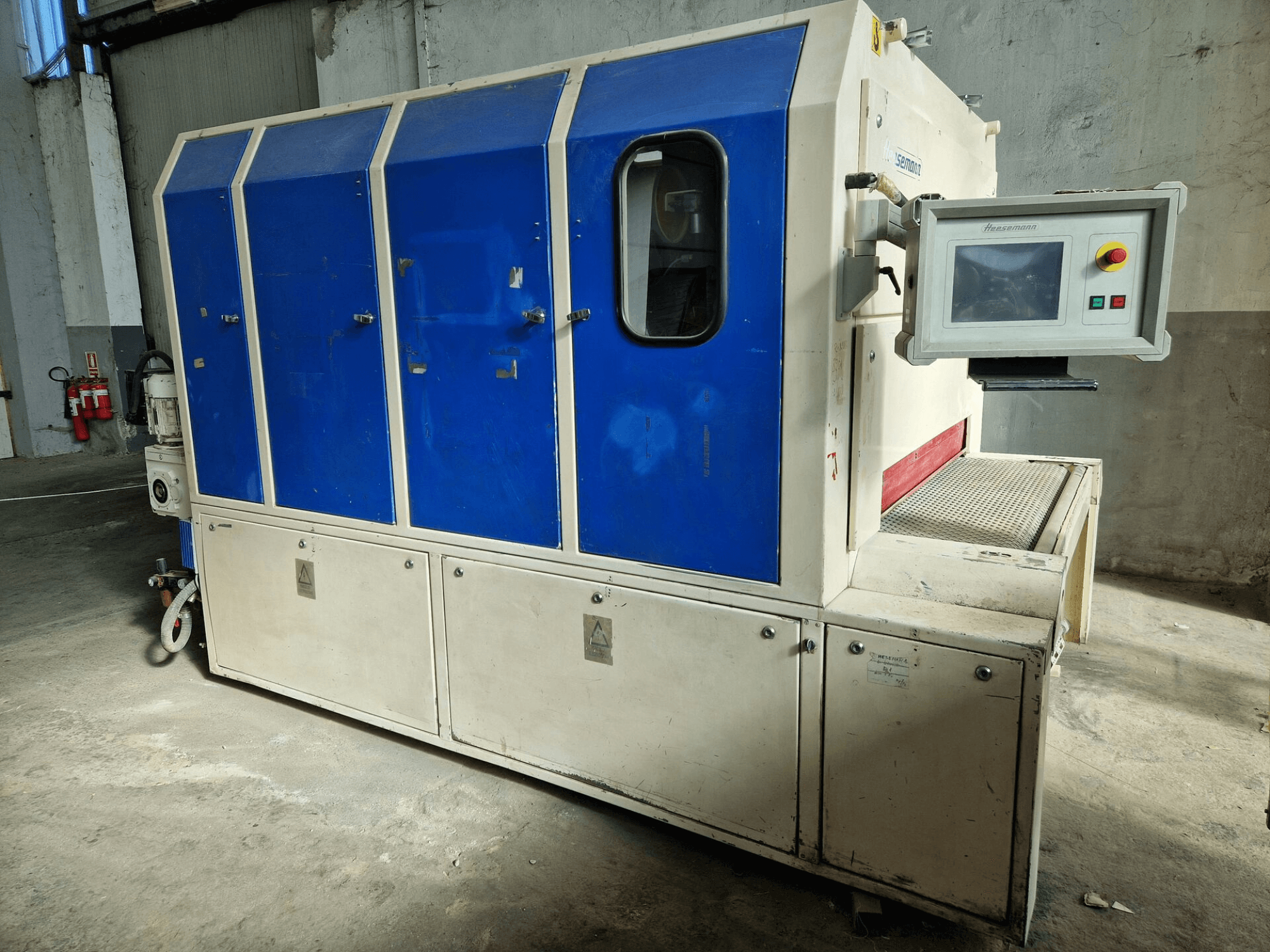 Tööstusmasin kaubamärgist "Sedecom", külgvaade; sinised paneelid, juhtimisekraan ja tekstuurne pind toodete käitlemiseks.