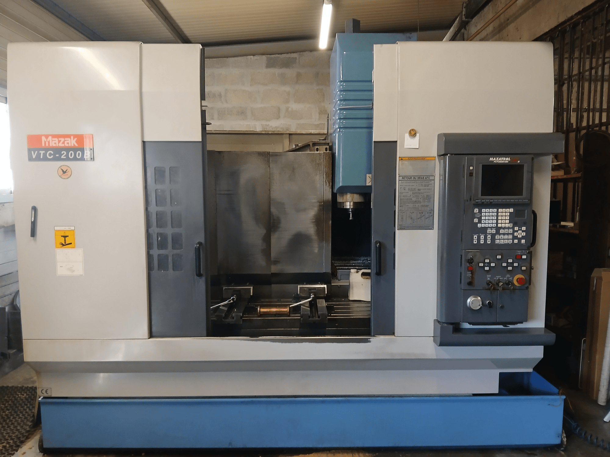 Mazak VTC 200 B vertikaalne töötluskeskus esiplaanil, kus on näha juhtpaneel, spindel ja tööala.