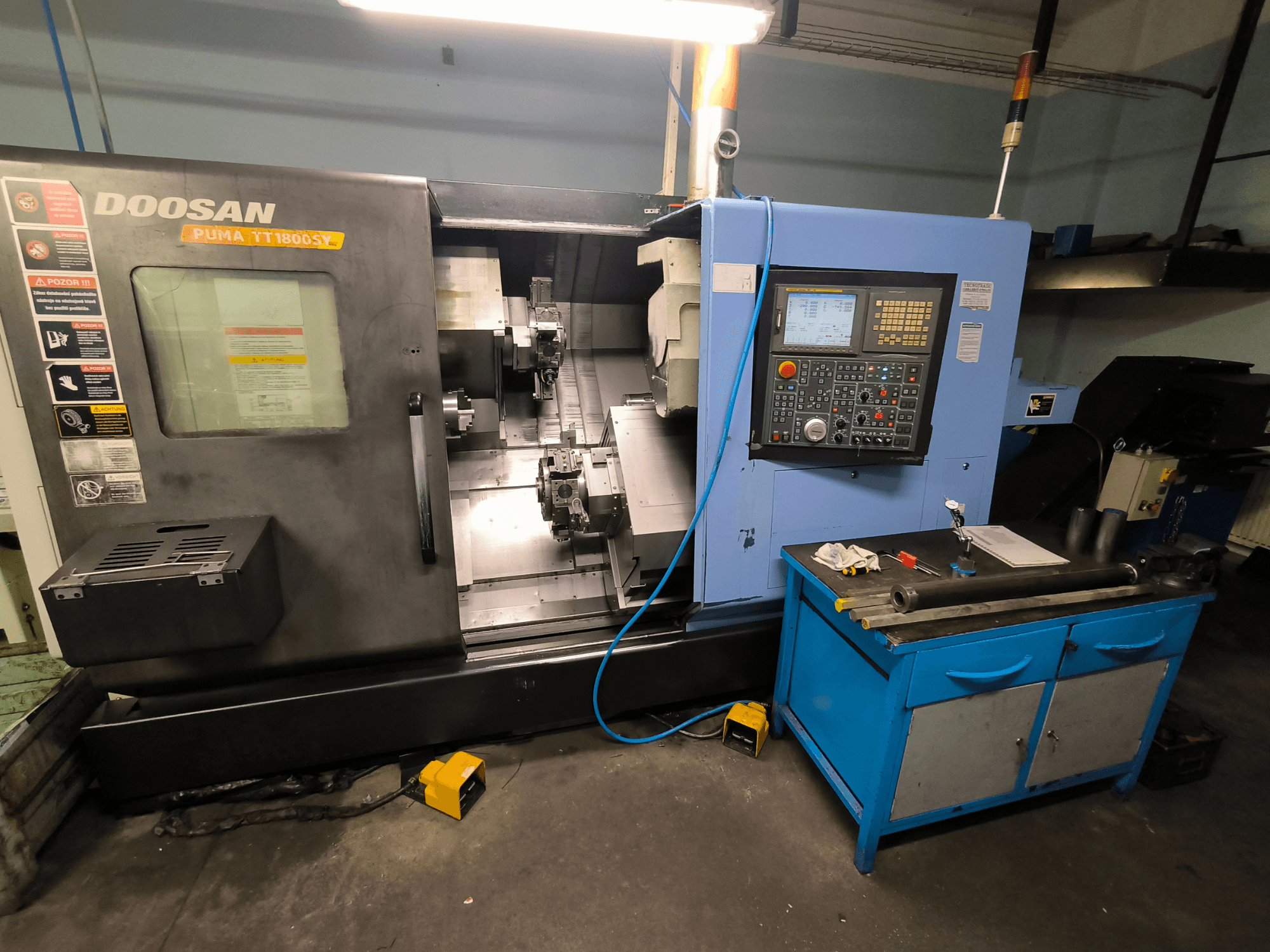 Doosan Puma TT1800SY CNC-teeninduspingi esivaade, kus on näidatud juhtpaneel, tööala koos tööriistadega ja masina komponendid.