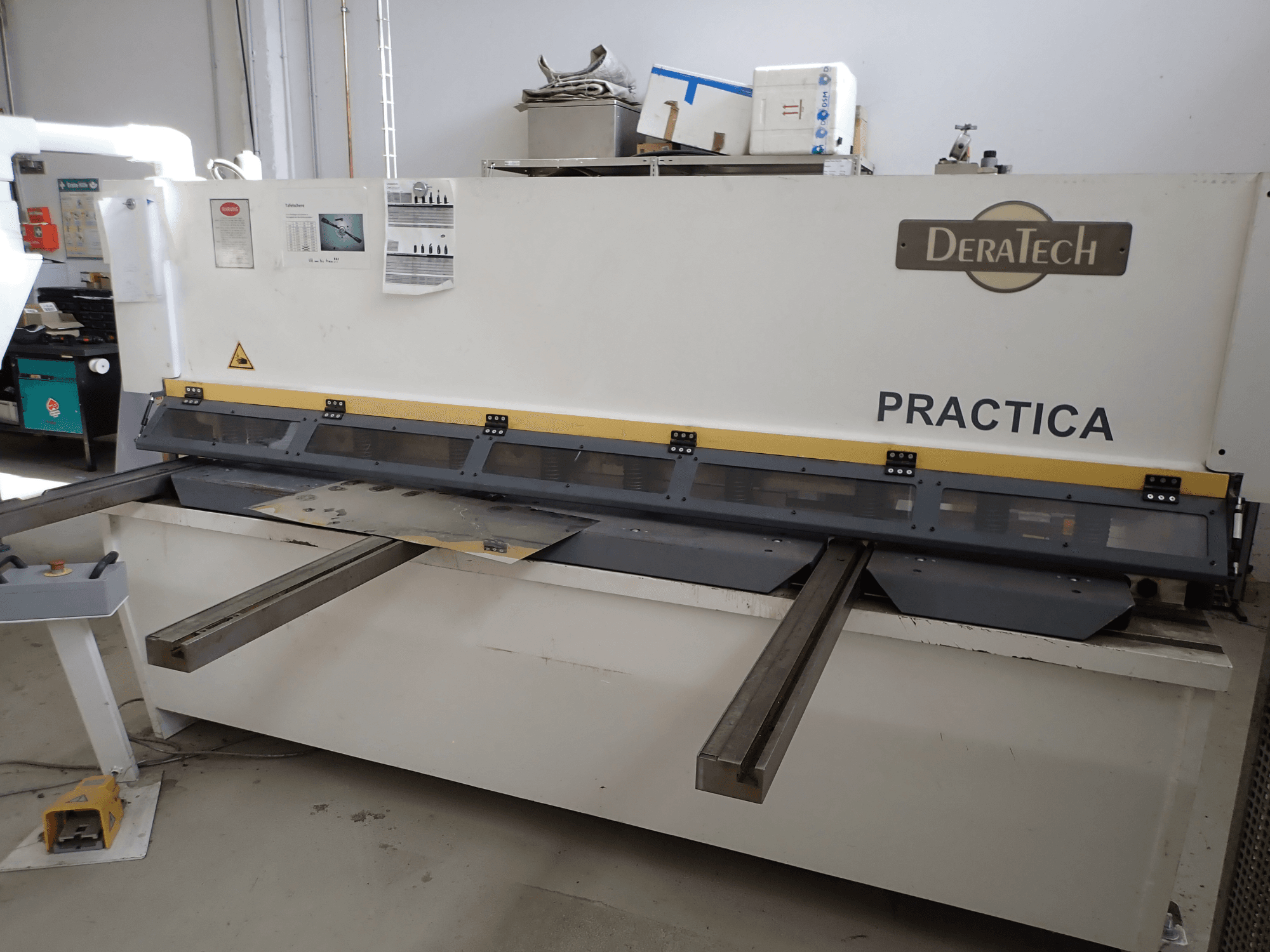 DERATECH Practica CNC lõikepink, esivaade, millel on näha lõiketera ja metallplaadid tööpinnal.