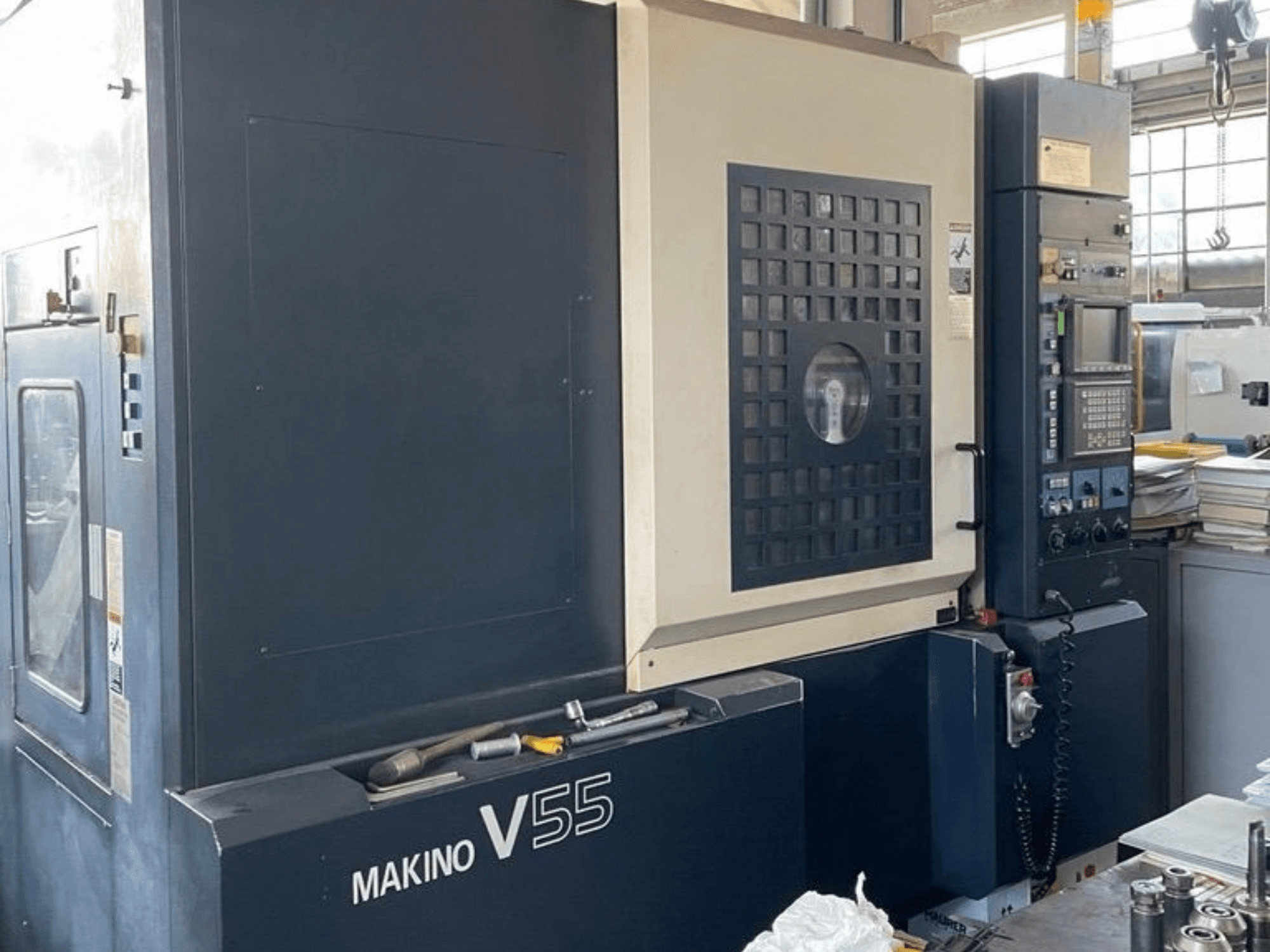 Makino V55-A15 vertikaalne töötlemiskeskus, esivaade, millel on näha juhtpaneel, tugev konstruktsioon ja töötsooni paigutus.