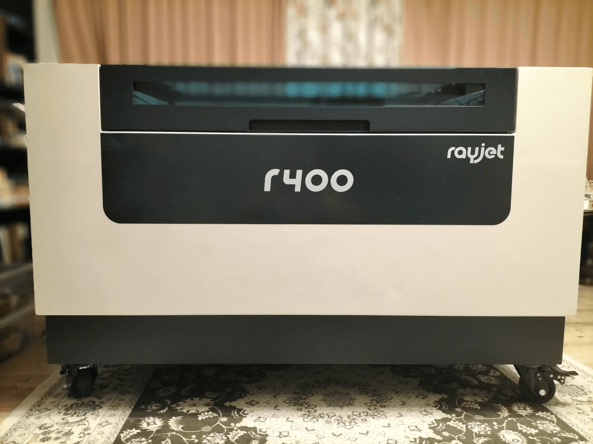 Trotec Rayjet R400 lasergraveerimismasina esiplaanil, mis näitab selle elegantset disaini ja selget kaubamärki.