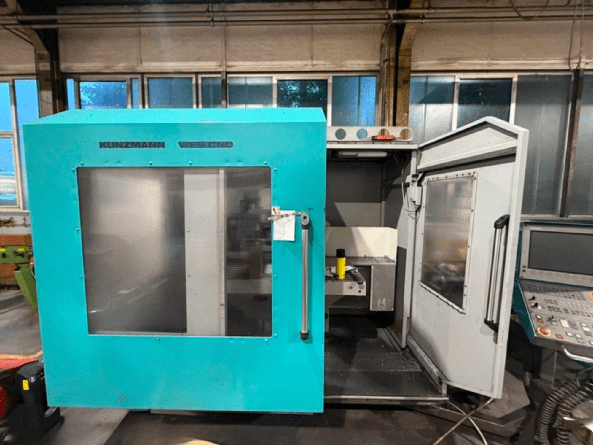 KUNZMANN WF9 CNC vertikaalne töötluskeskus, esivaade avatud ustega, kus on näha sisemus ja juhtpaneel.