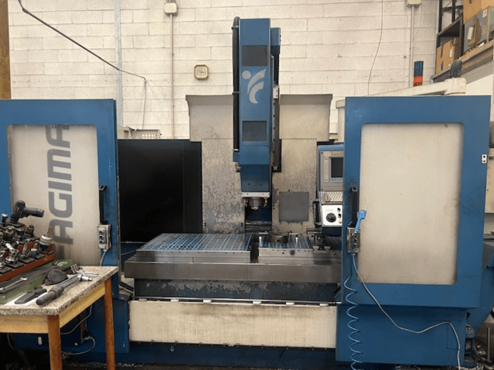 JAGIMA CNC-pingi esivaade suure metallist tööruumi, nähtava juhtpaneeli ja lähedalasuval laual olevate tööriistadega.