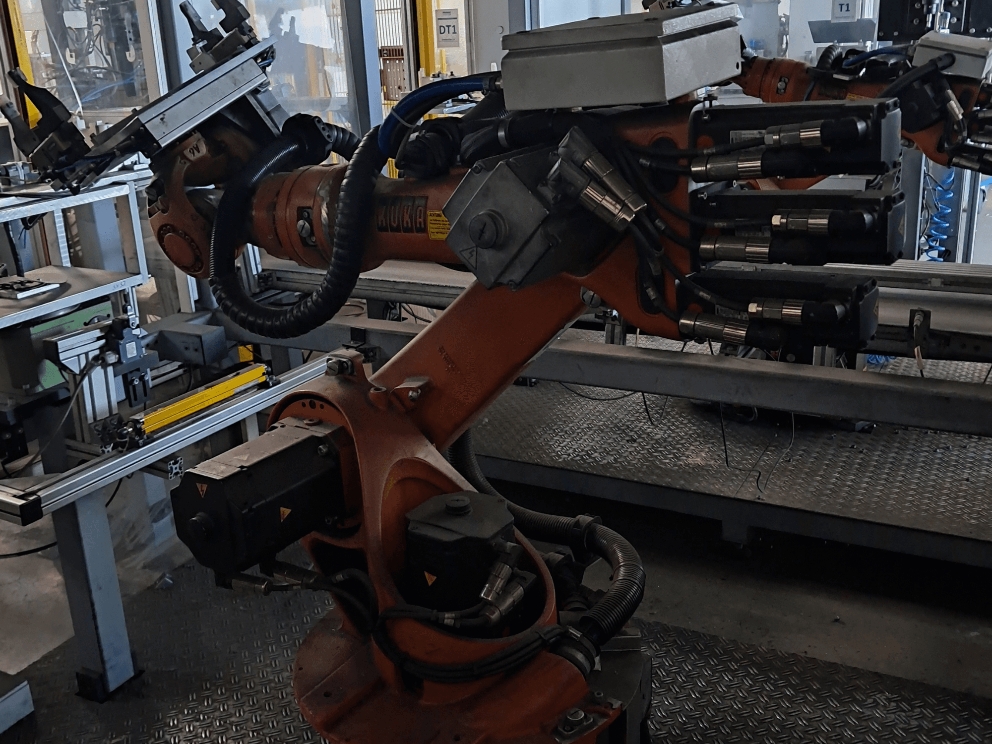 KUKA KR 16-2 robotkäsi koos KRC 4 juhtseadmega, külgvaates, millel on näha liigendliigendid ja hüdraulilised ühendused.