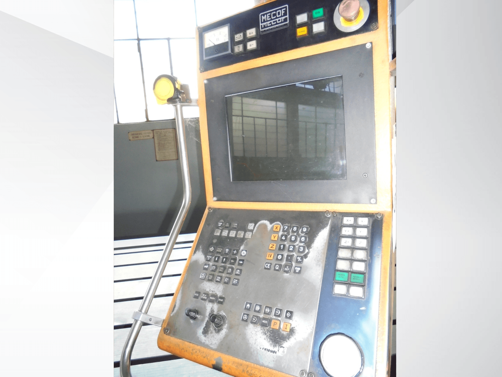 Mecof juhtpaneel, millel on digitaalne näidik, nupud ja nupud; esiplaanil on näha juhtimisseadmete kulumist.