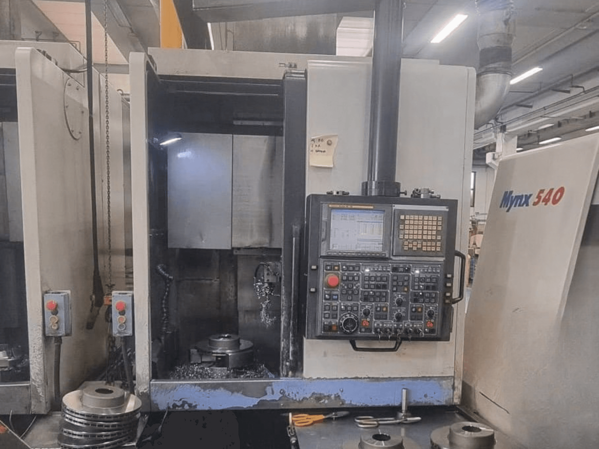 DOOSAN PUMA V400-2SP vertikaalse treipingi esivaade, millel on näha juhtpaneel ja töödeldava detaili paigutus masina sees.