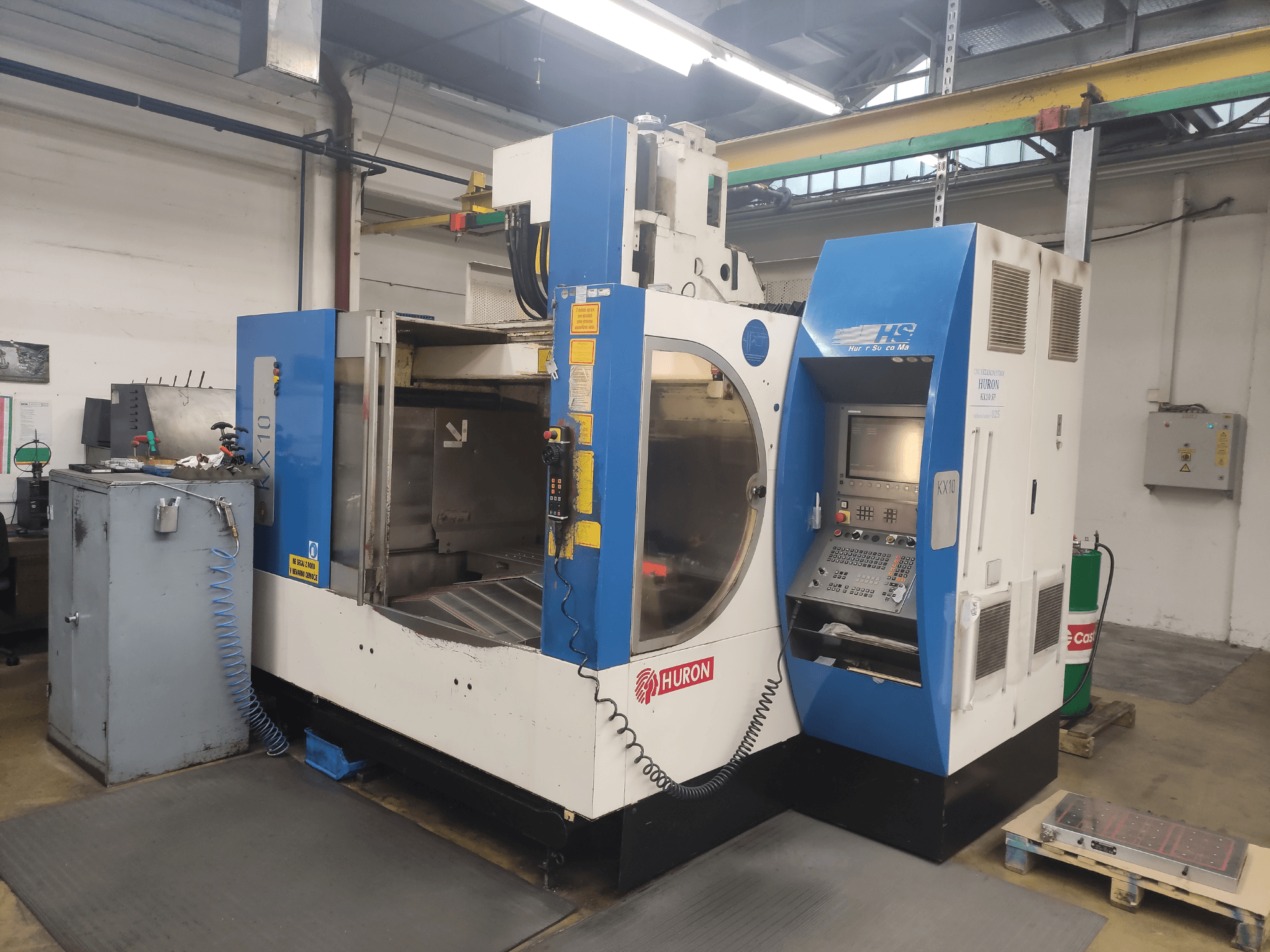 HURON KX10 CNC-tööpink töökojas, esivaade, juhtpaneel ja suur ava töötluseks.