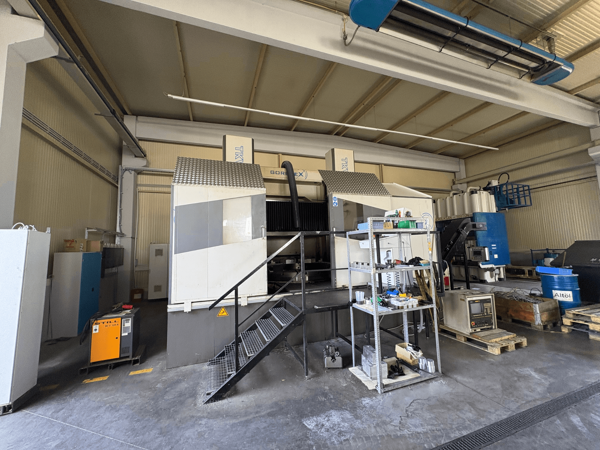 Tööstuslik mehaaniline seade GORAT X masinaga, külgvaade; sisaldab tööriistu, juhtpaneeli ja riiulitel olevaid seadmeid.