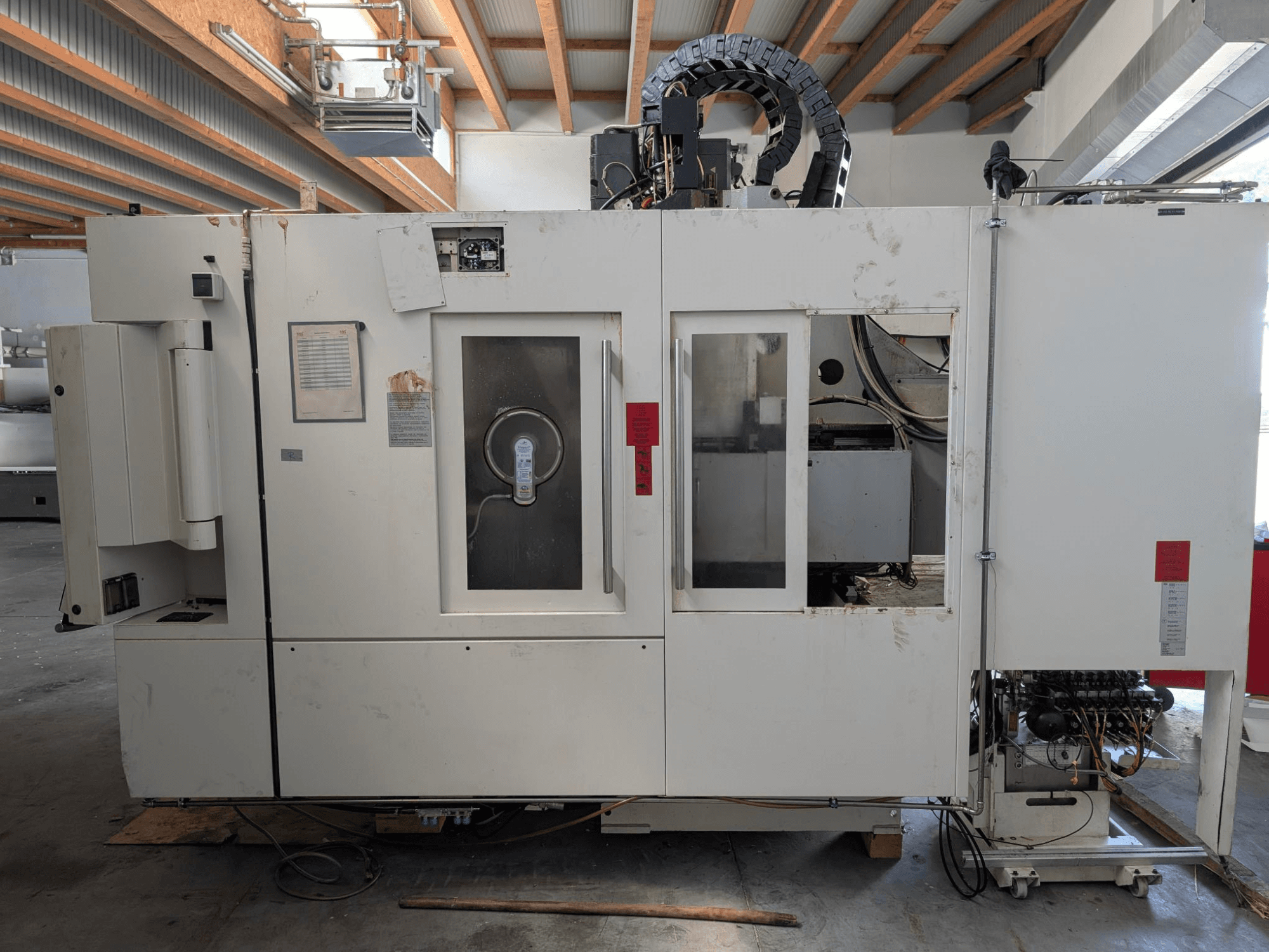 STAMA MC 326 vertikaalne töötlemiskeskus, külgvaade, millel on näidatud juhtpaneel, spindli ala ja erinevad sildid masinal.