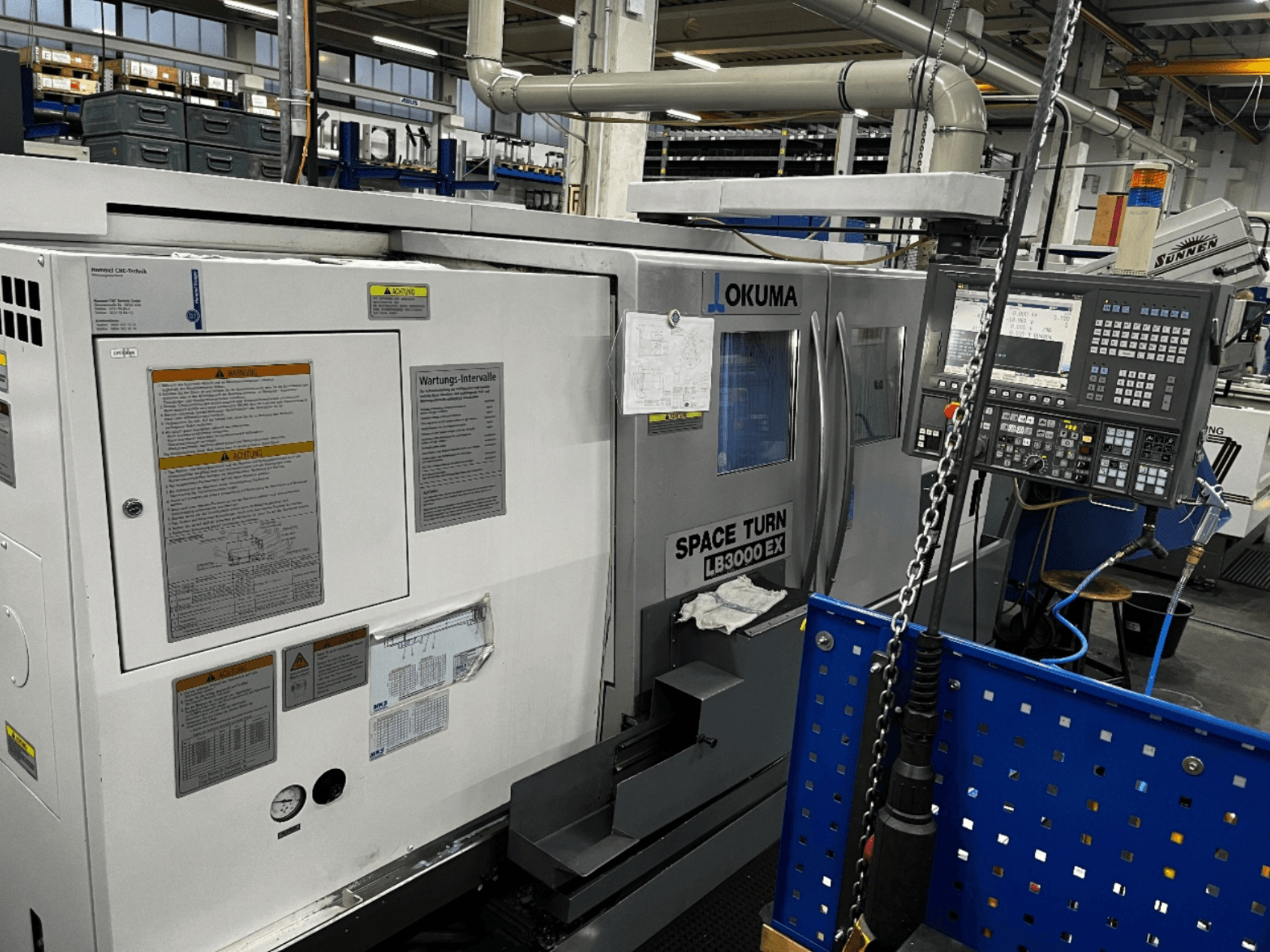 Okuma LB3000 EX horisontaalne treipingi, esiplaanil, küljel on juhtpaneel ja ohutusteave.