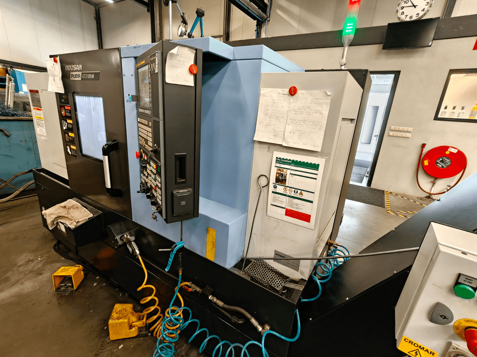 DOOSAN Puma GT 2100M horisontaalse treipingi esikülg, kus on näha juhtpaneel, ohutusseadmed ja hooldusmärkused.