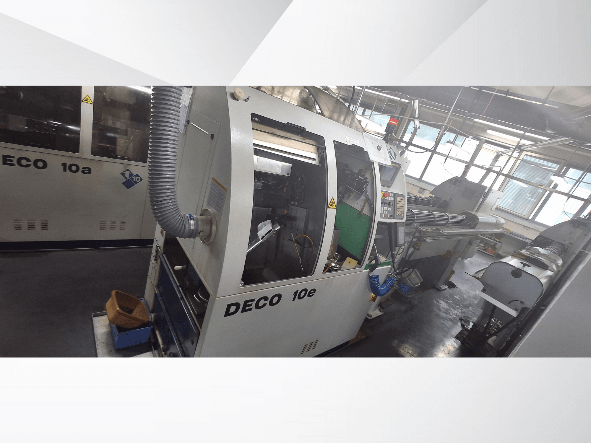 DECO 10e CNC masin külgvaates, millel on juhtpaneel, roheline sisemus ja ühendatud väljalasketoru.