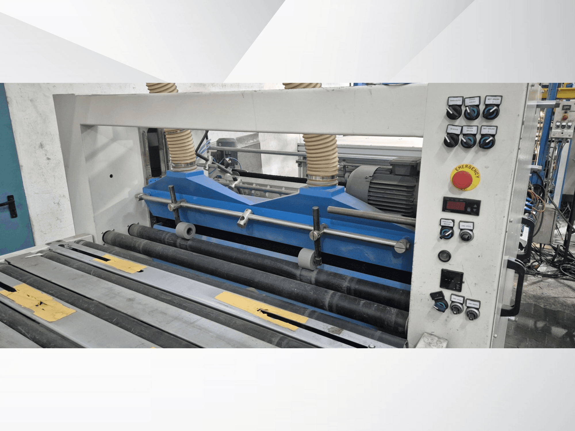 Siniste komponentidega tööstuslik rullimismasin, esivaade, millel on juhtpaneel ja hädaseiskamisnupp.