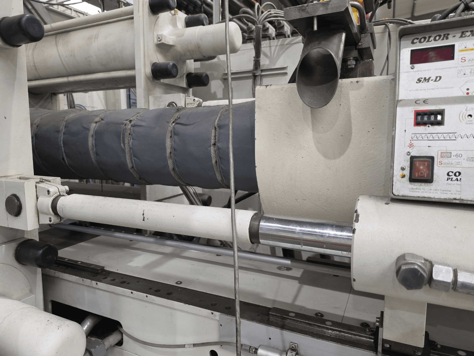 Krauss Maffei 350-3000 CX hüdrauliline survevalu masin, külgvaates on näha temperatuuri juhtpaneel ja kütteelemendid.