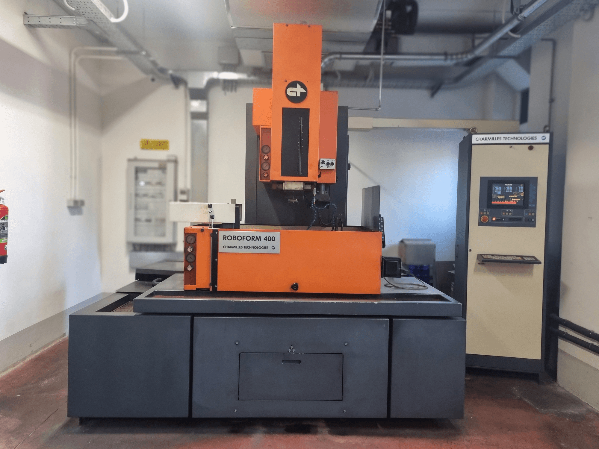 Charmilles Technologies'i Roboforn 400 masin, esiplaanil, oranž ja hall kujundus, digitaalne juhtpaneel nähtav.