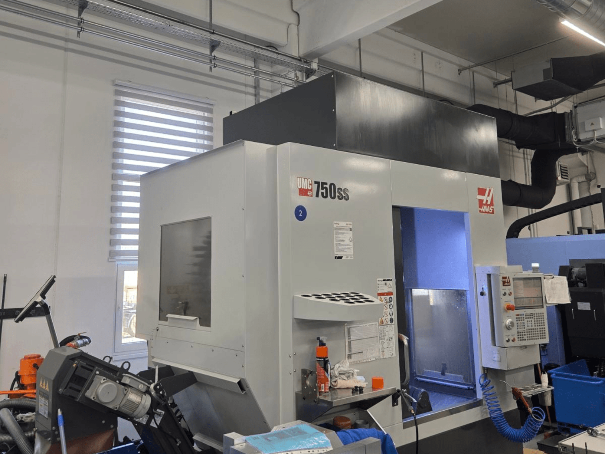 Haas UMC-750SS vertikaalne töötlemiskeskus, esiplaan, juhtpaneel ja vaba juurdepääs töötlemisalale.