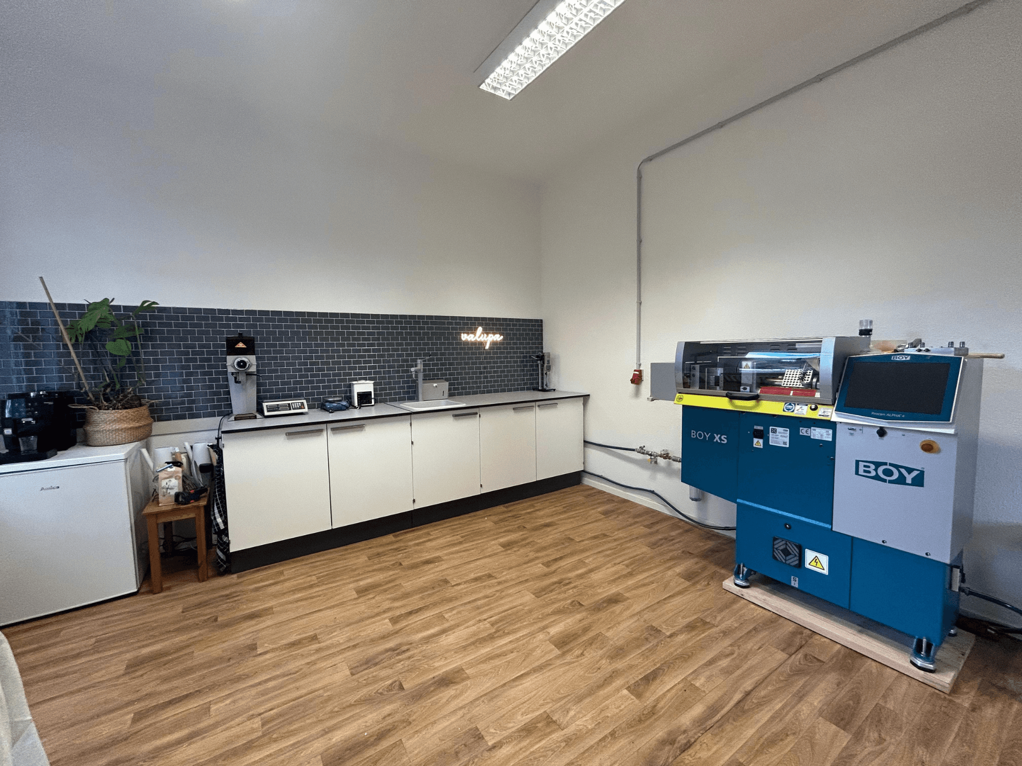 Hüdrauliline survevalu masin BOY XS 161, esiplaanil, moodsas köögis koos seadmete ja puitpõrandaga.