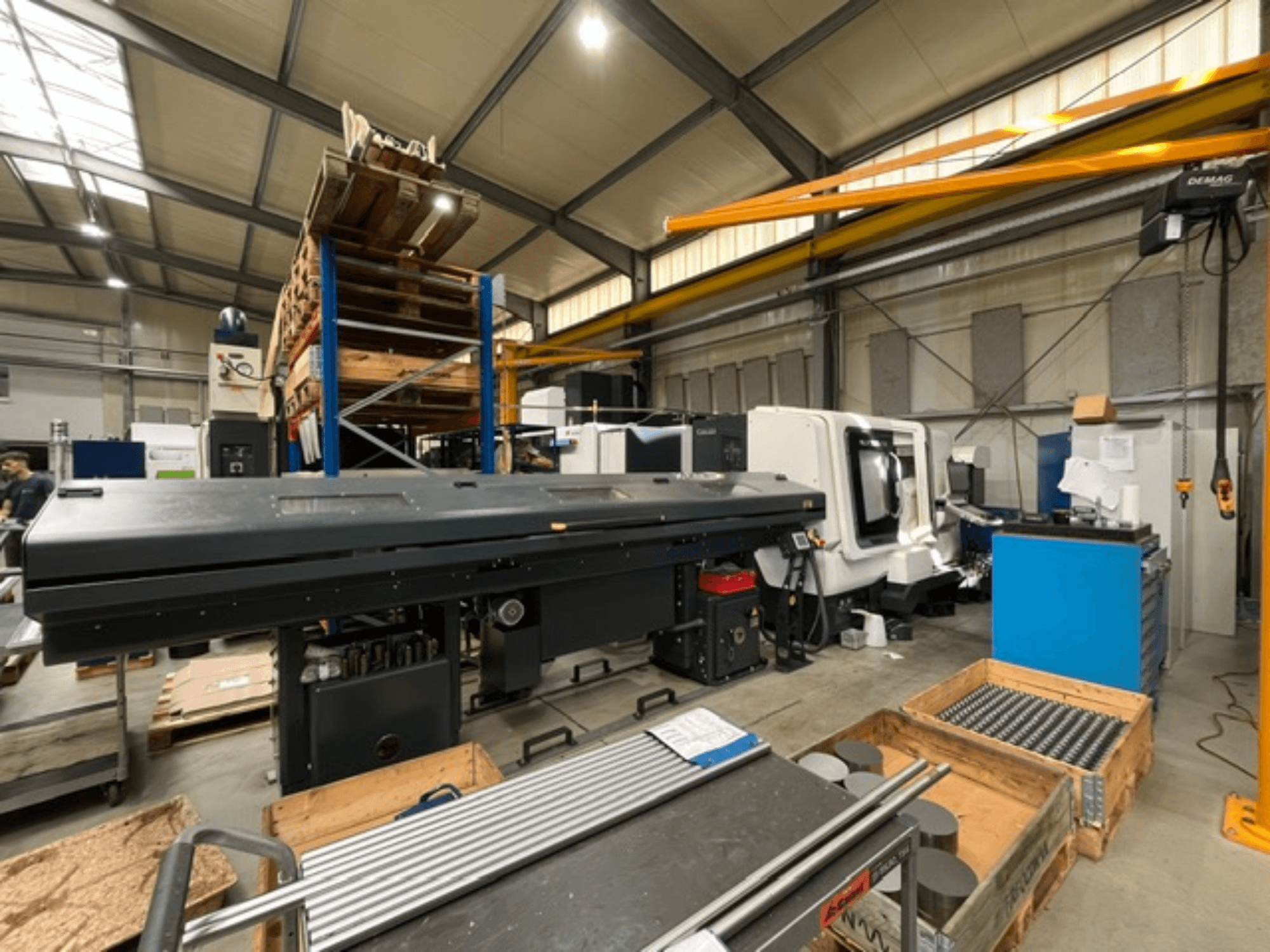 DMG MORI MORI NLX 2500/700 SY horisontaalne treipink tehase keskkonnas, vaade küljelt, näha on tööriistad ja alused.