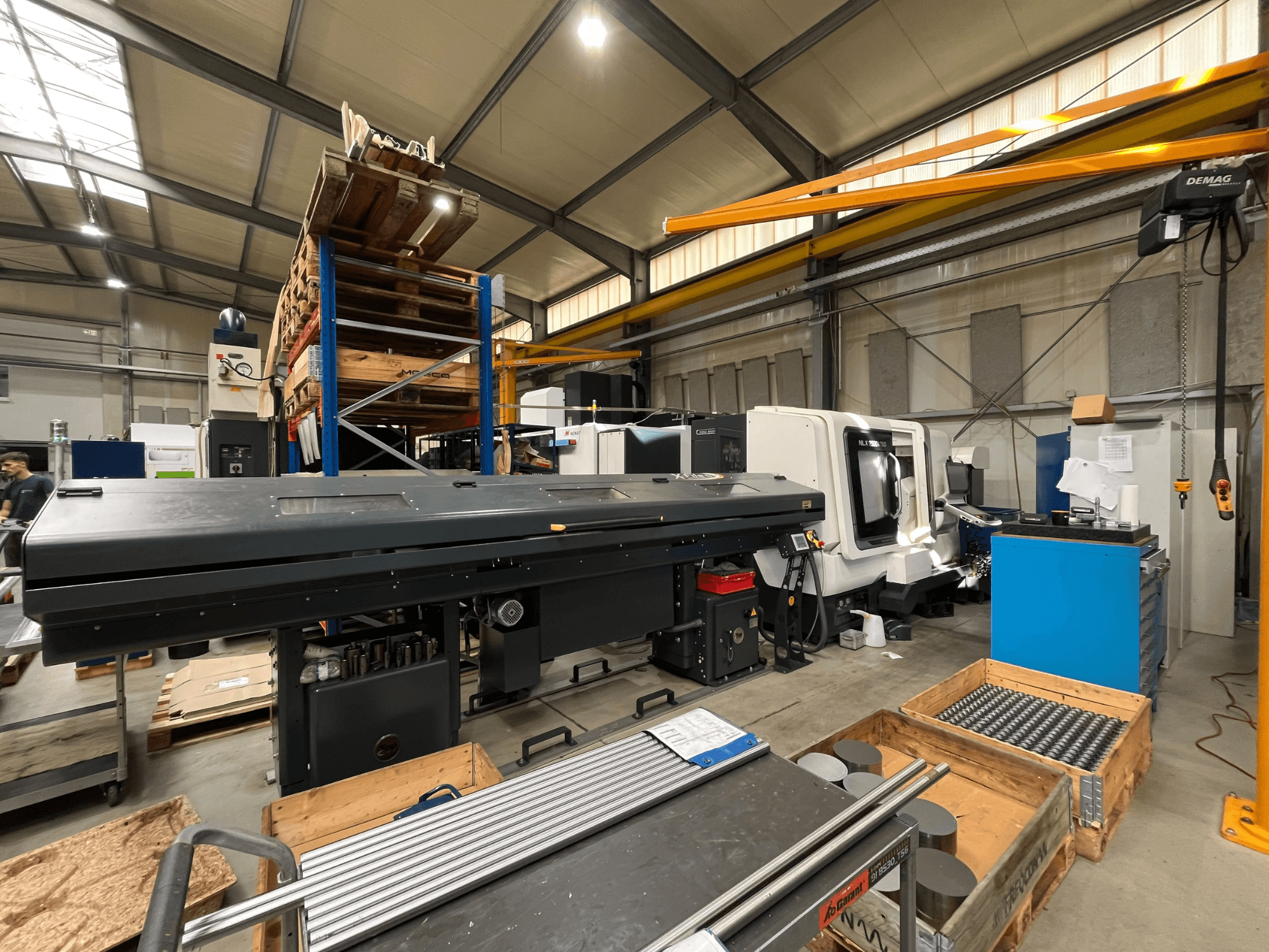 Töökojas asuv horisontaalne treipink DMG MORI MORI NLX 2500/700 SY, vaade küljelt, taustal ladustamisruum ja tööriistad.