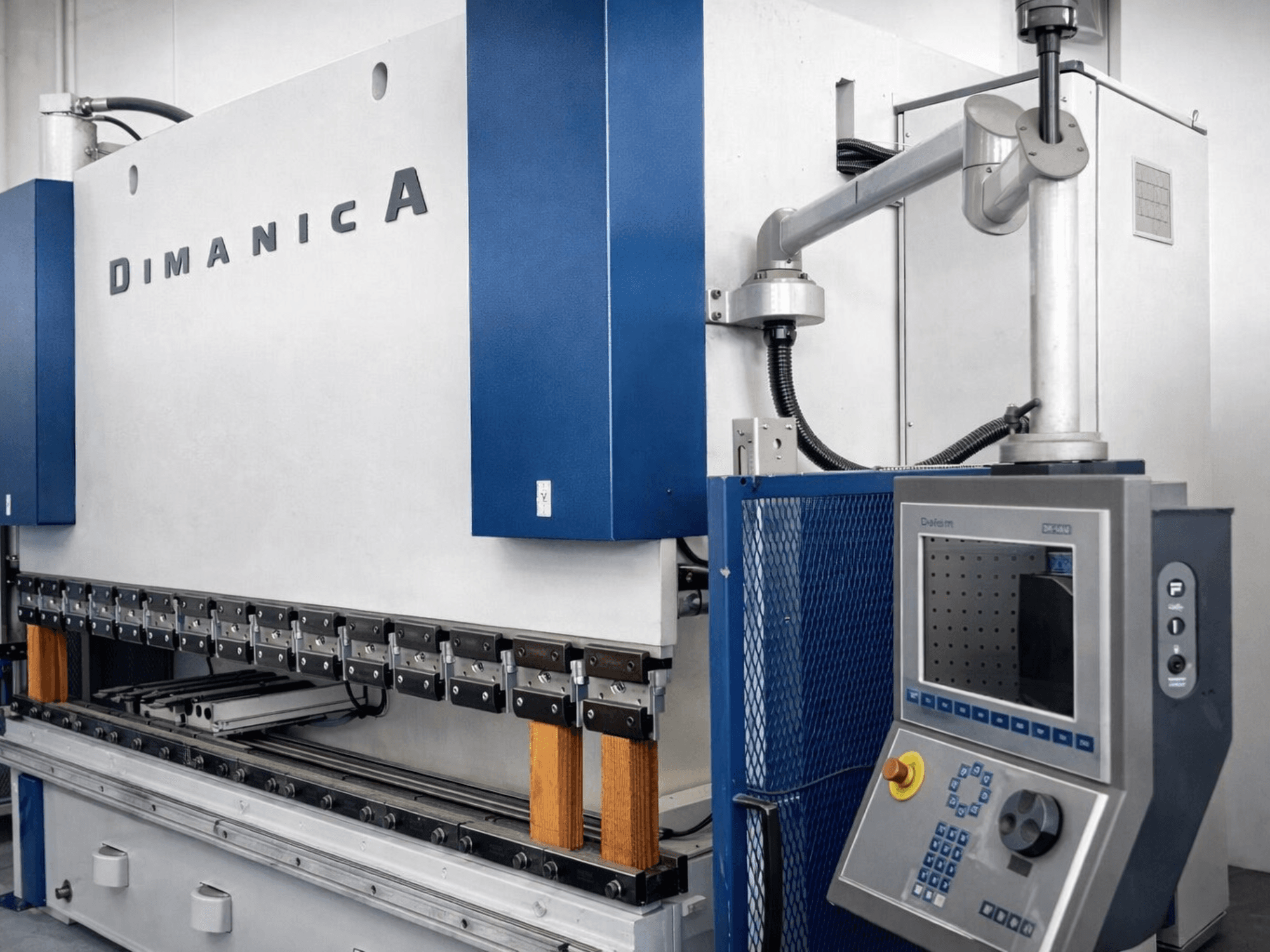 Warcomi presspink DINAMICA 3000x100, külgvaade, kus näidatakse juhtpaneeli ja painutusvahendeid metallitöötluseks.