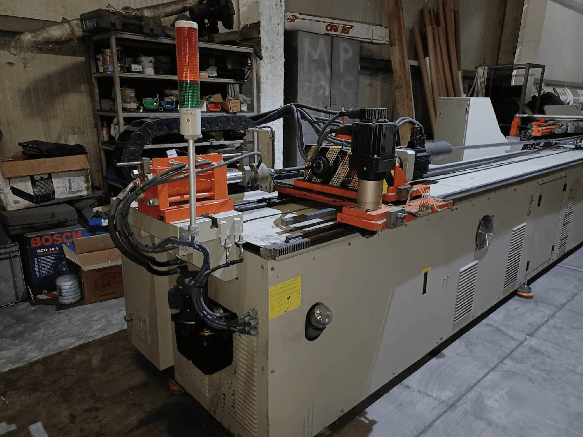 Plaadipainutusmasin CANSA CNC 51 R1, külgvaade, millel on näha juhtpaneel, mootor ja märgutuled töökoha keskkonnas.