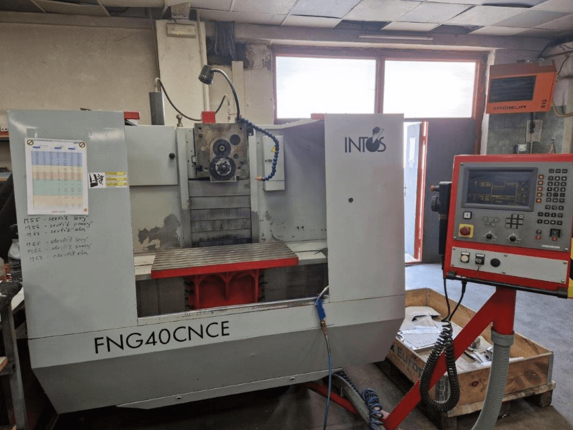 INTOS FNG40CNC masin, esivaade, millel on juhtpaneel, tööosad ja metallist töölaud. Ideaalne töötlemiseks.