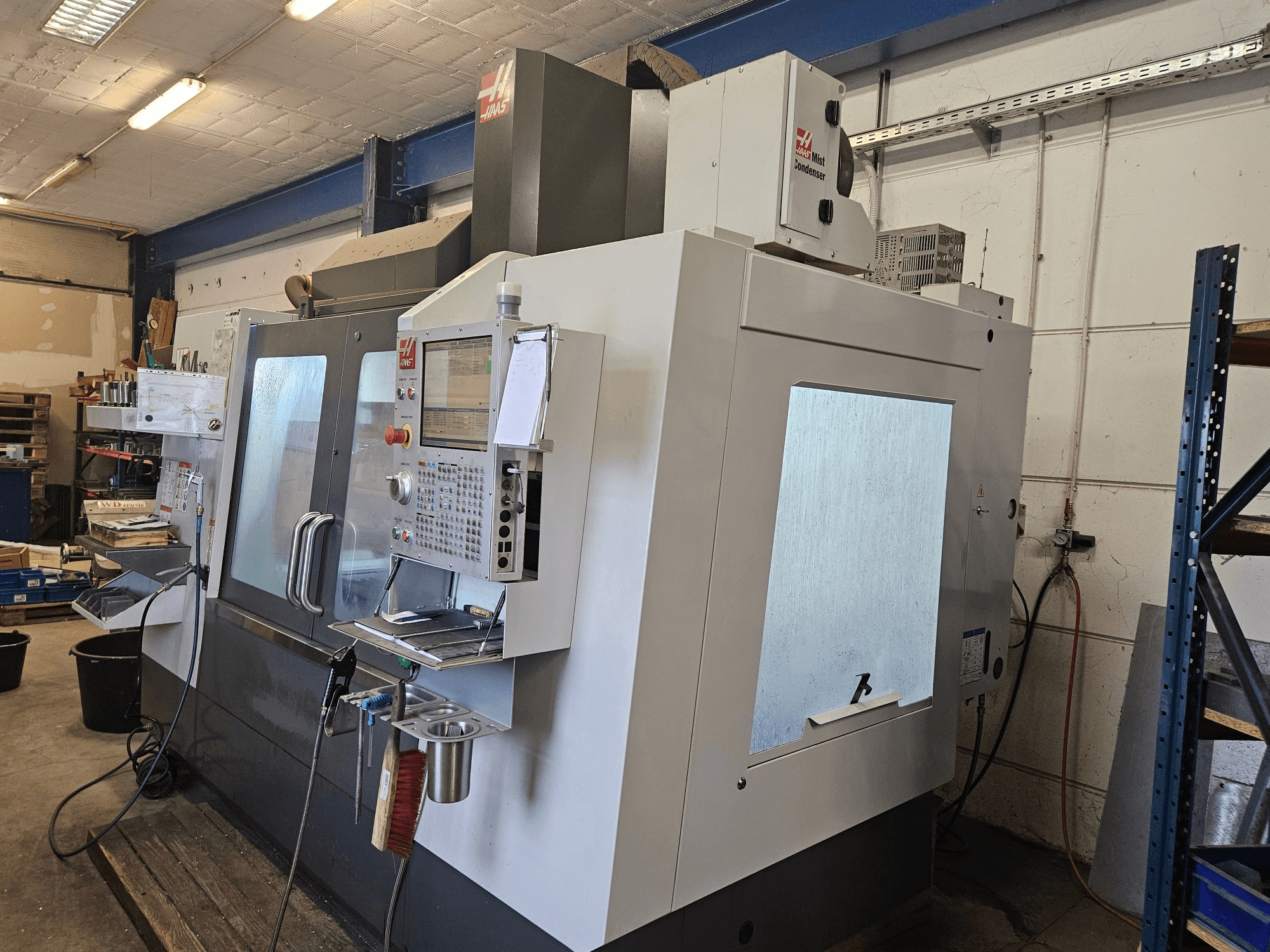 HAAS VF-4SS vertikaalne töötlemiskeskus eestvaates, millel on juhtpaneel ja suured vaatamisaknad.