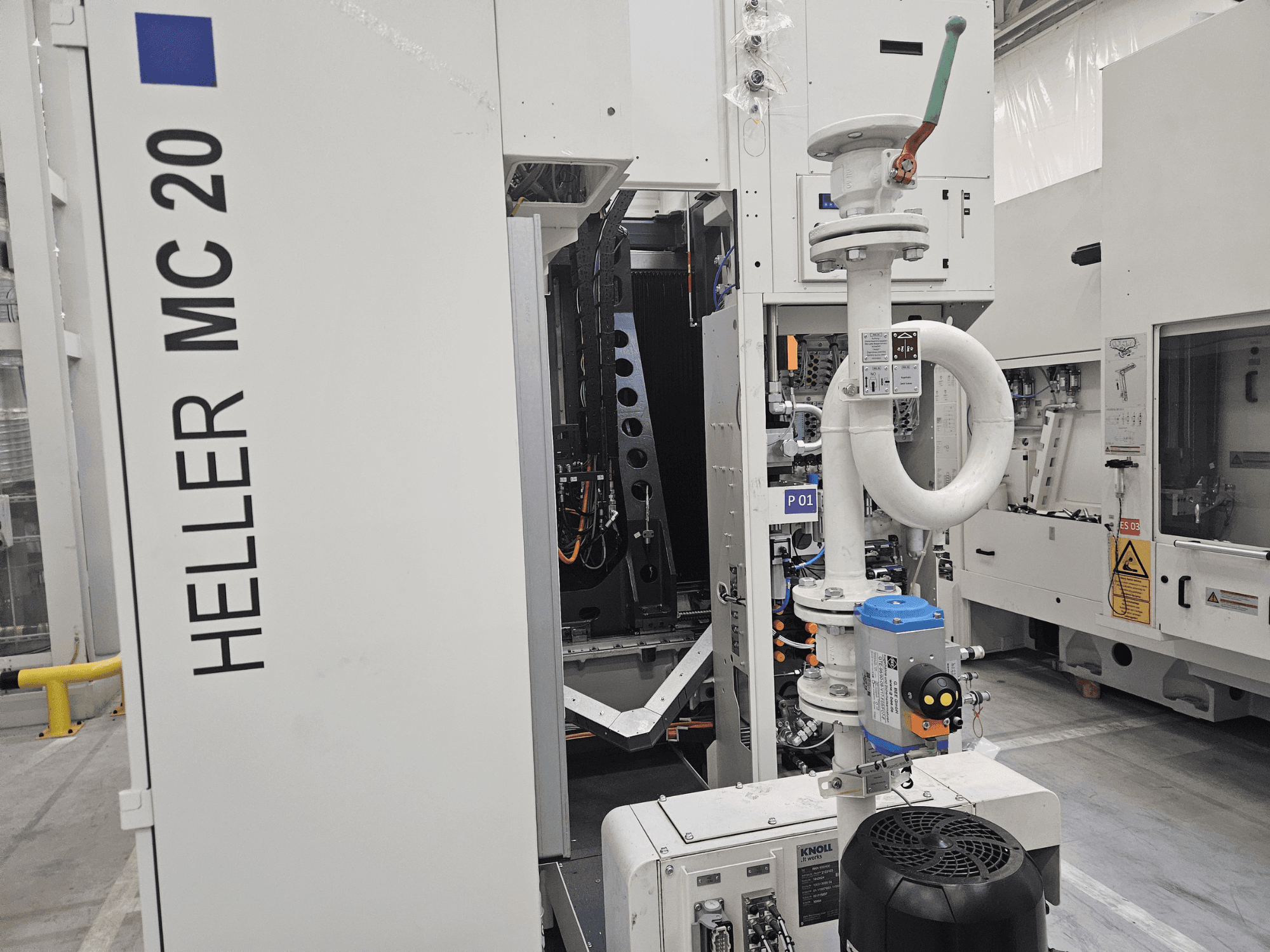 Heller MC 20 masin tehases, kus näidatakse juhtpaneeli ja mehaanilisi komponente külgvaates.