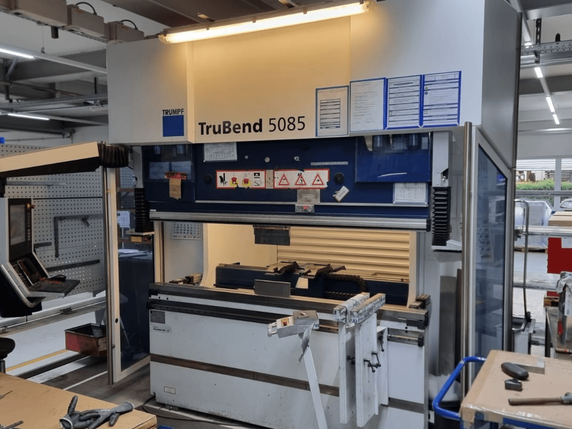 TRUMPF TruBend 5085 painutusmasin, esivaade, kus on näidatud juhtpaneel, tööjaam ja ohutushoiatused töökojas.