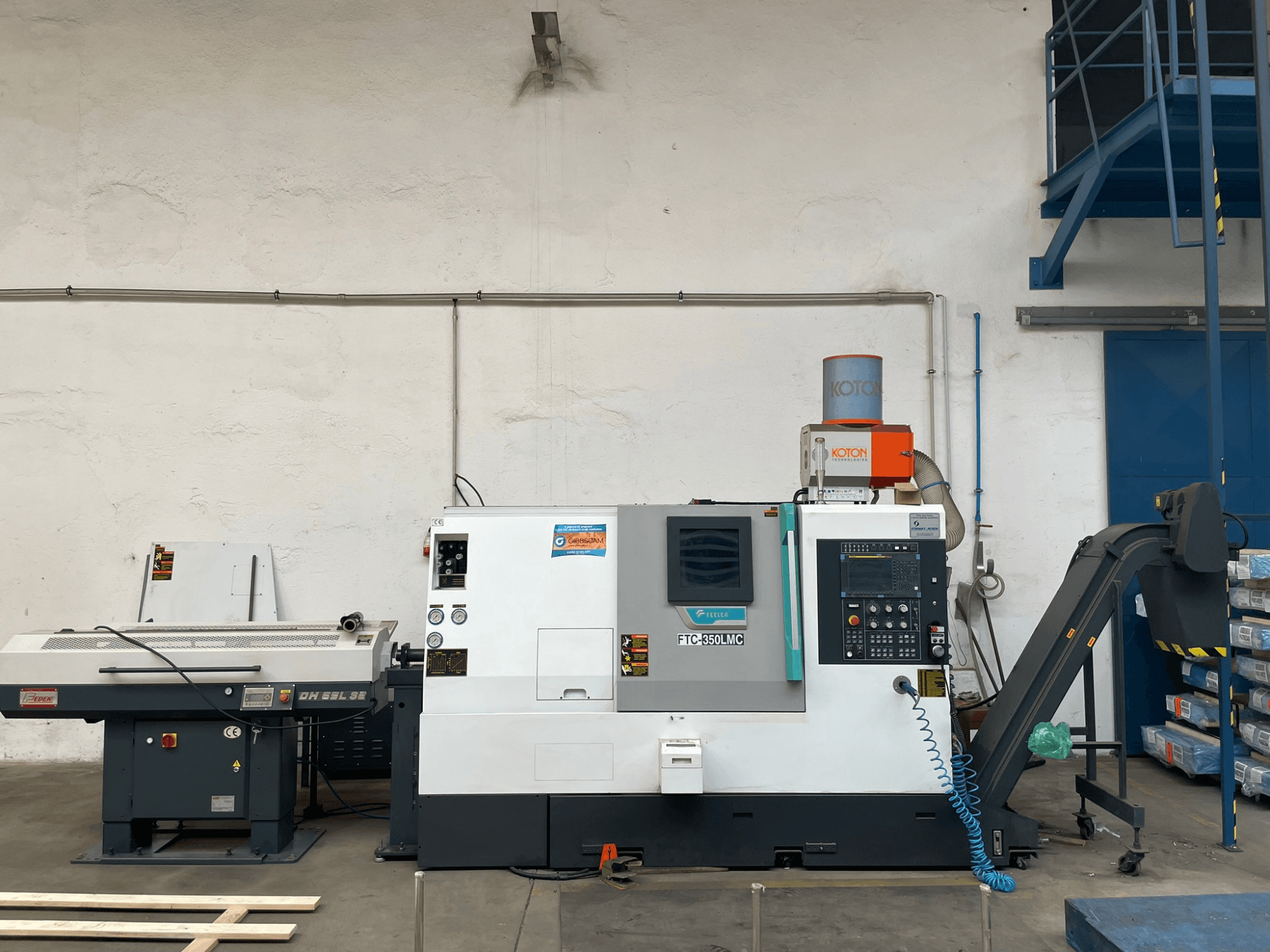 Feeler FTC 350 LMC horisontaalne treipink töökojas, kus näidatakse juhtpaneeli ja tööriistade etteandmisliine. Külgvaade.