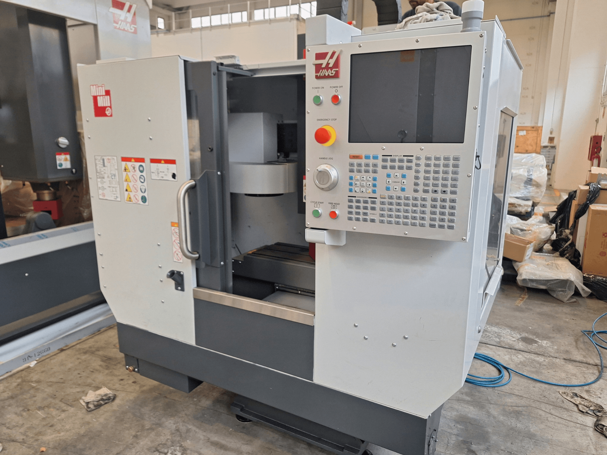 HAAS Mini Mill vertikaalne töötlemiskeskus vaadatuna eestpoolt, millel on nuppudega juhtpaneel ja ekraan.