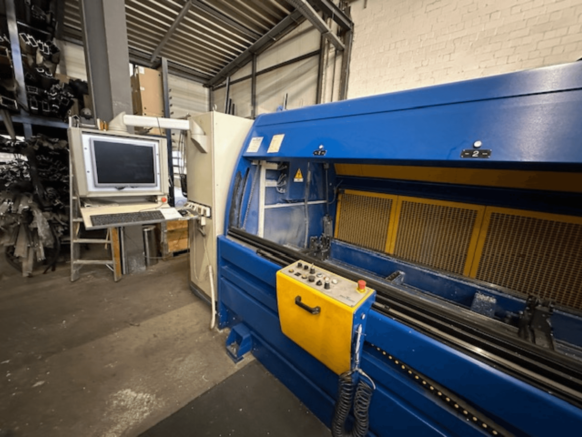 SCHÜCO Profilbearbeitungscenter 299 650, universaalne töötluskeskus koos juhtimisseadmete ja arvutitöökohaga, esiplaanil.