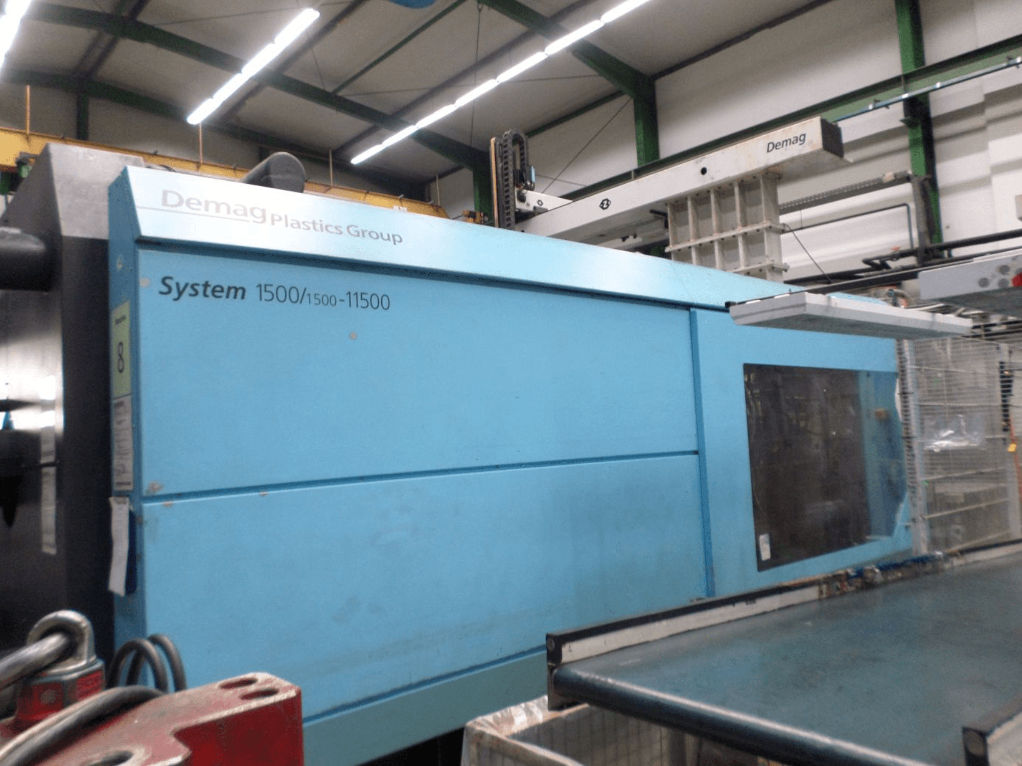 Sinine hüdrauliline süstimisvormimismasin Demag D 650, külgvaade, millel on näha System 1500/1500-11500 silt ja tööpiirkond.