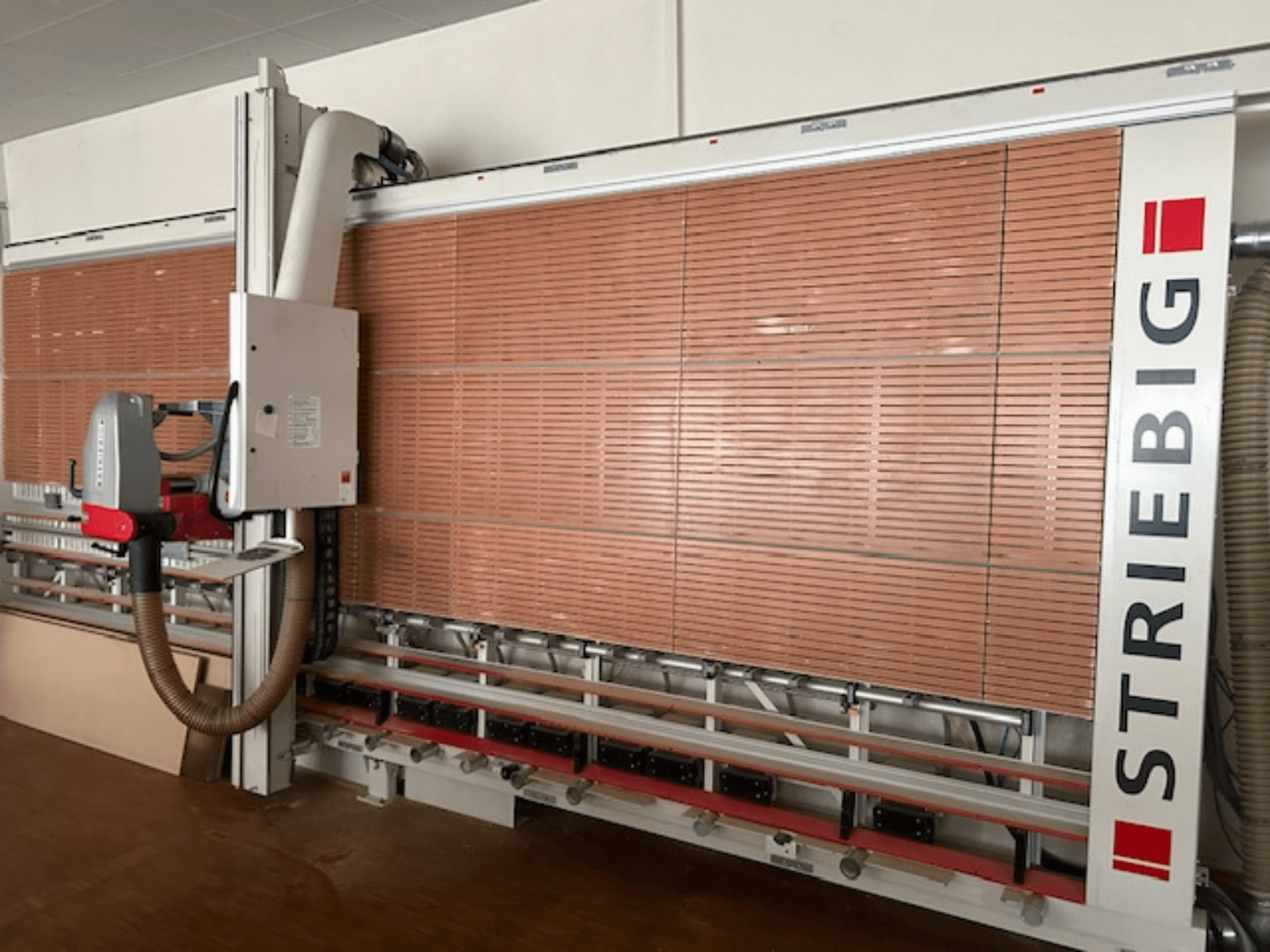 Striebig vertikaalne plaadisaag külgvaates, millel on mootoriga pea, puitplaatide lõiketerad ja tolmuimejasüsteem.