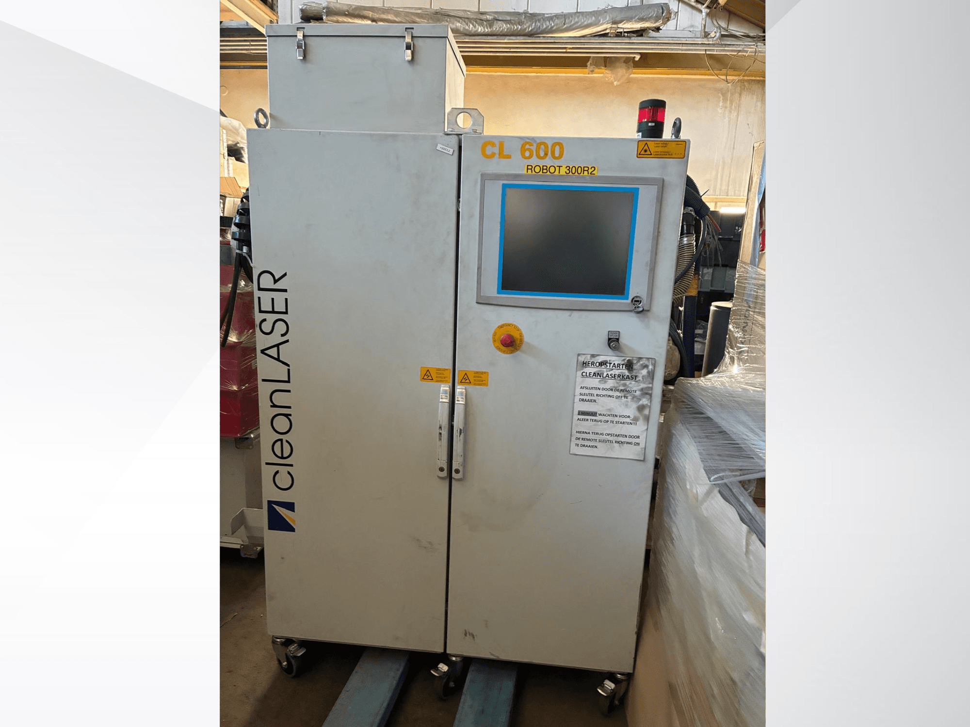 CLEAN LASER CL 600 automatiseerimissüsteem eestvaates, millel on LCD-ekraan, hoiatussildid ja ukse peal asuvad juhtnupud.