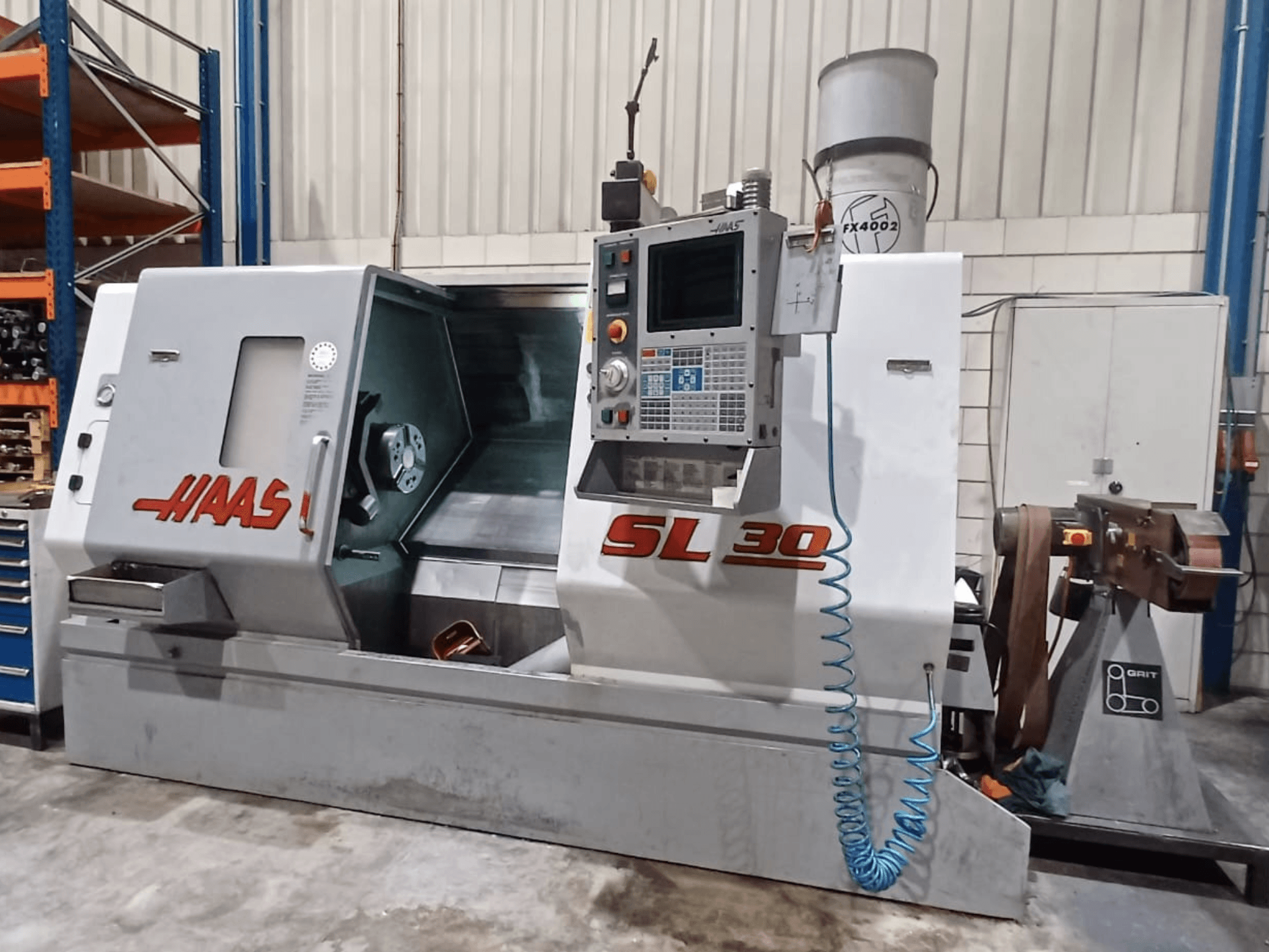 Haas SL 30 CNC-teenindusega treipingi külgvaates, kus näidatakse juhtpaneeli, töötlemisala ja metallitööde jaoks integreeritud jahutusvedeliku süsteemi.