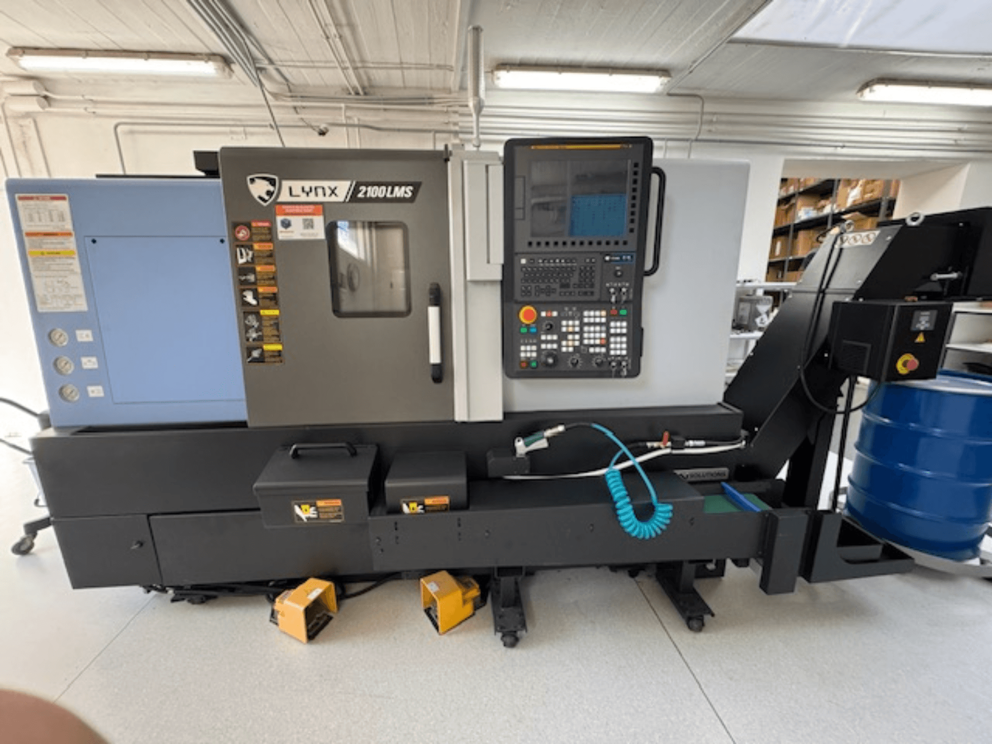 DOOSAN LYNX 2100LMSA horisontaalne treipink, esivaade, juhtpaneel, jahutusvedeliku voolik ja hoiukastid.