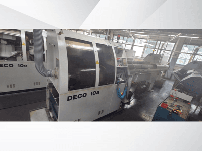 DECO 10a CNC-tööpink töökojas, kus on näha esiosa, juhtpaneel ja väljalaskesüsteem. Omadused: tugev konstruktsioon ja täppistööriistad.