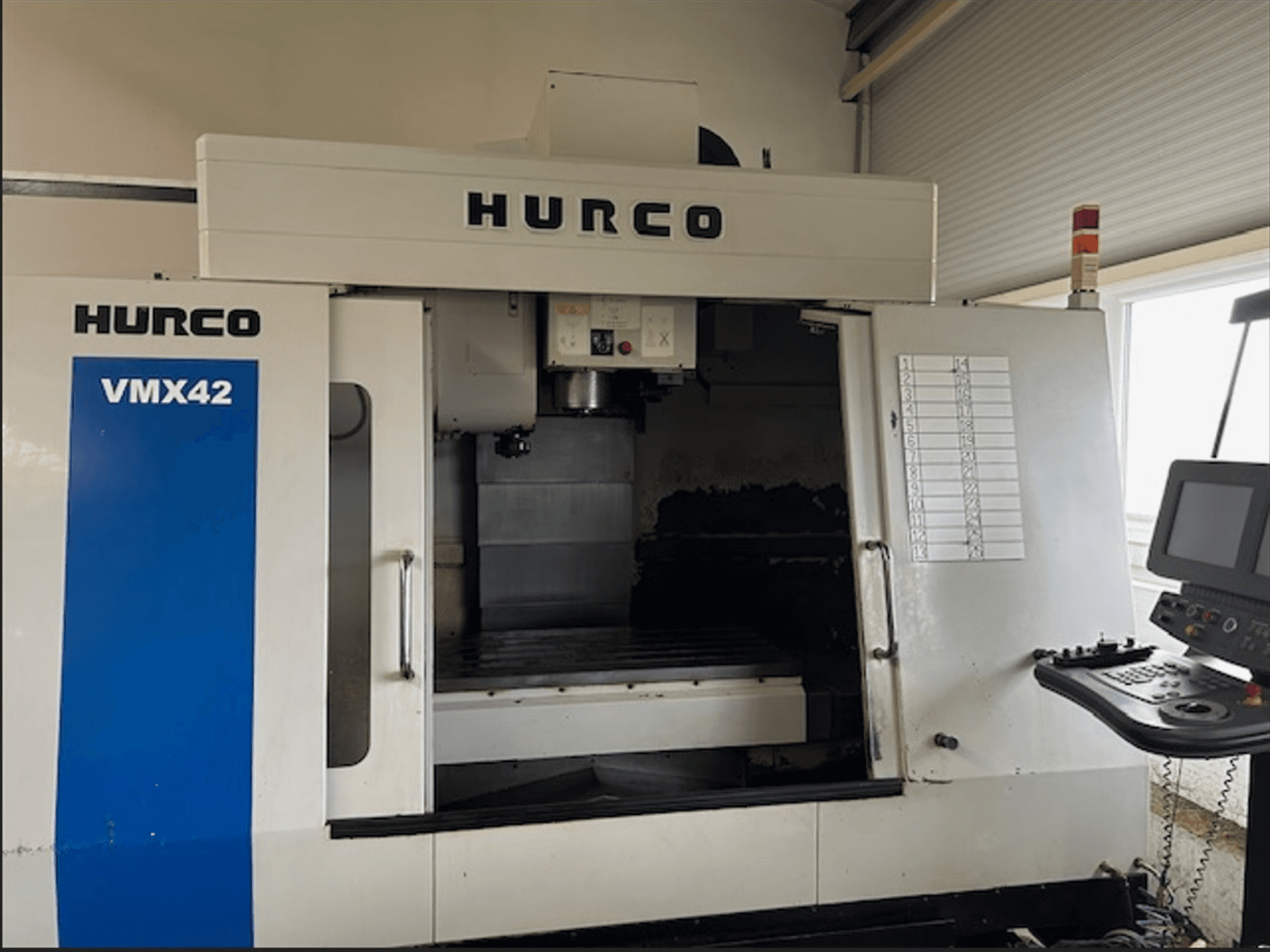 Hurco VMX42 CNC-freesping, esivaade, juhtpaneel ja avatud tööruum töötlemistoiminguteks.