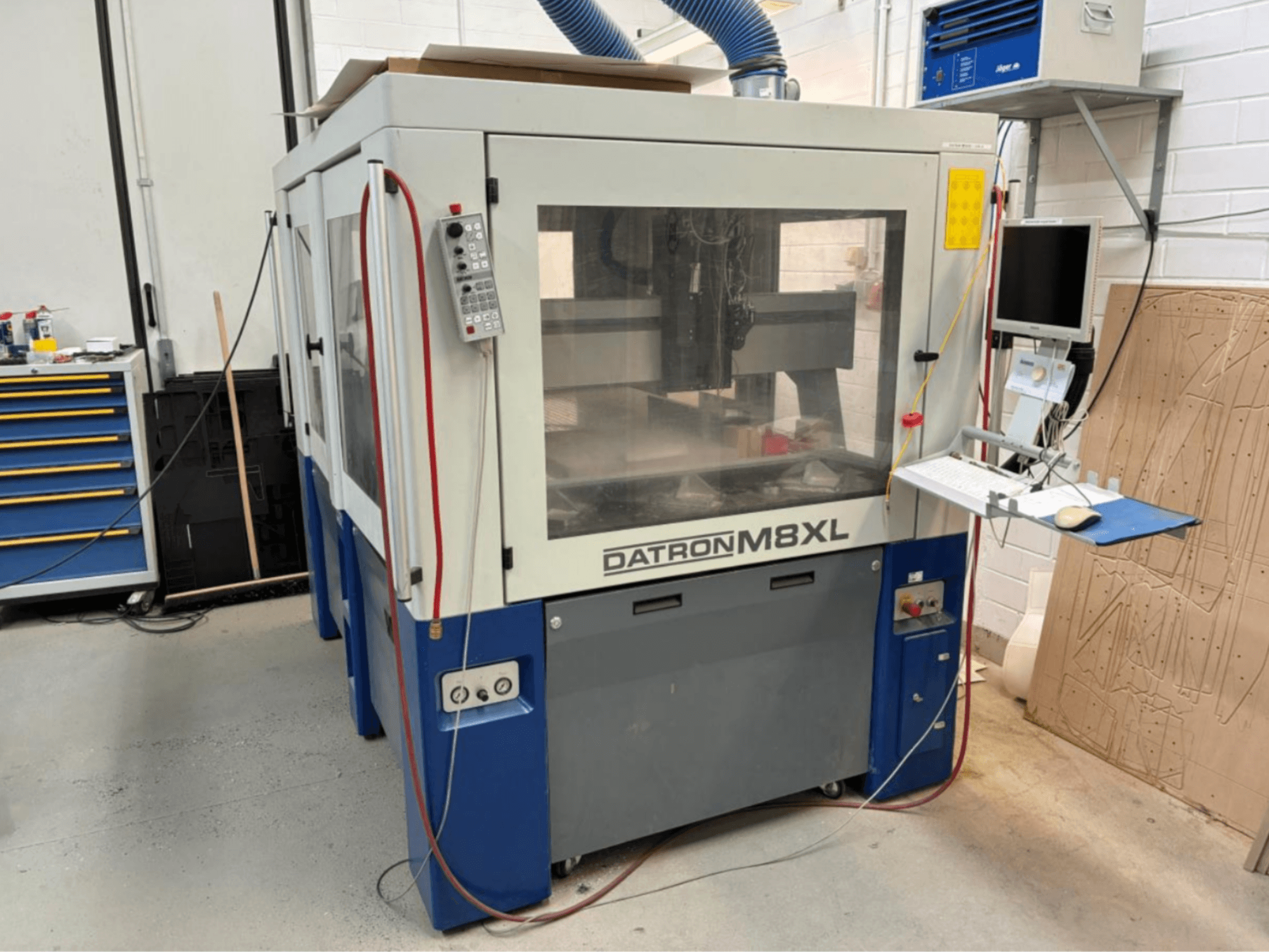 DATRON M8XL CNC-tööpink töökojas, esivaade, kõrval on paigaldatud juhtpaneel ja monitor.