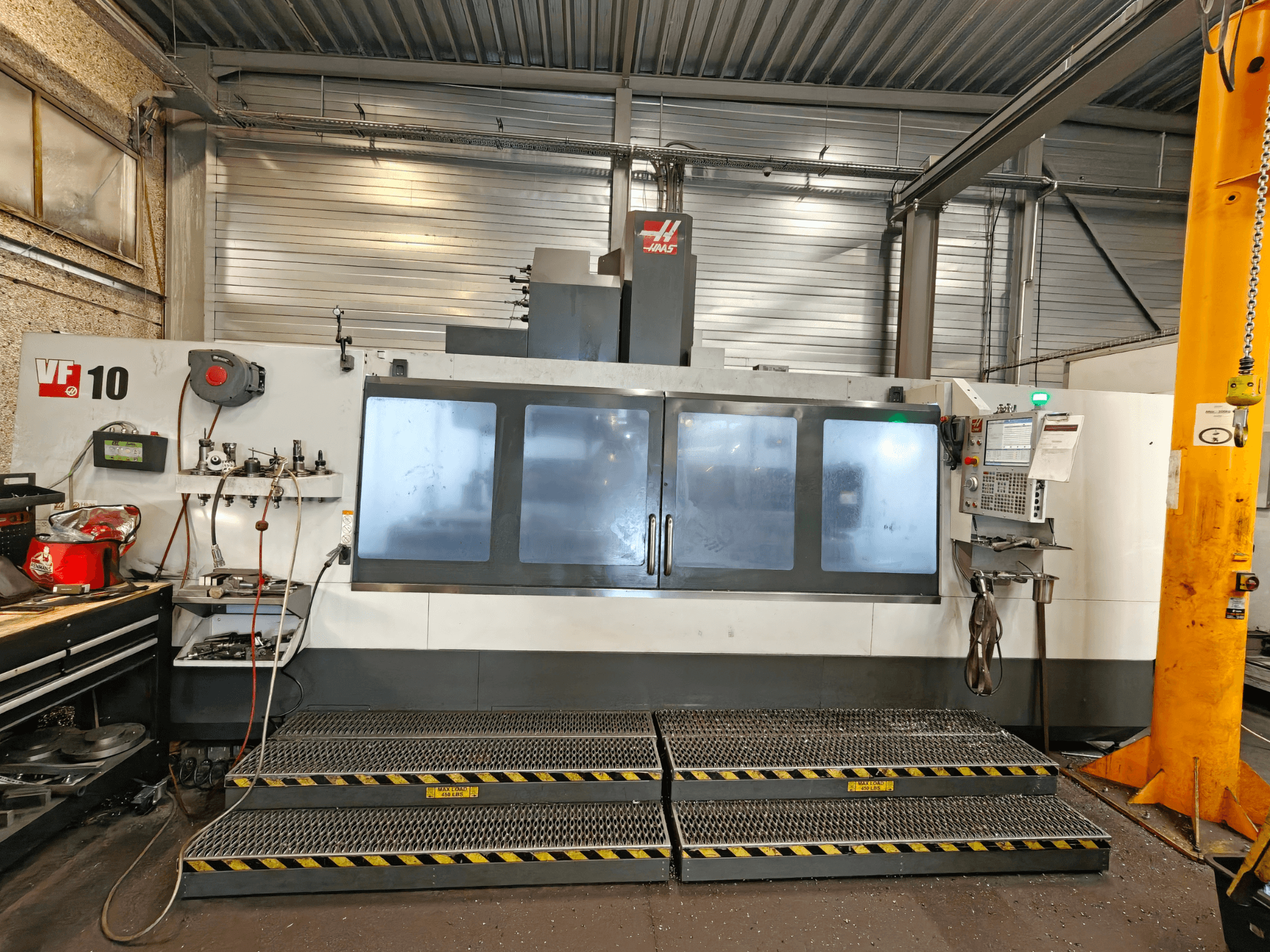 HAAS VF-10/50 vertikaalne töötlemiskeskus, vaade eest, millel on juhtpaneelid ja suured vaatamisaknad.