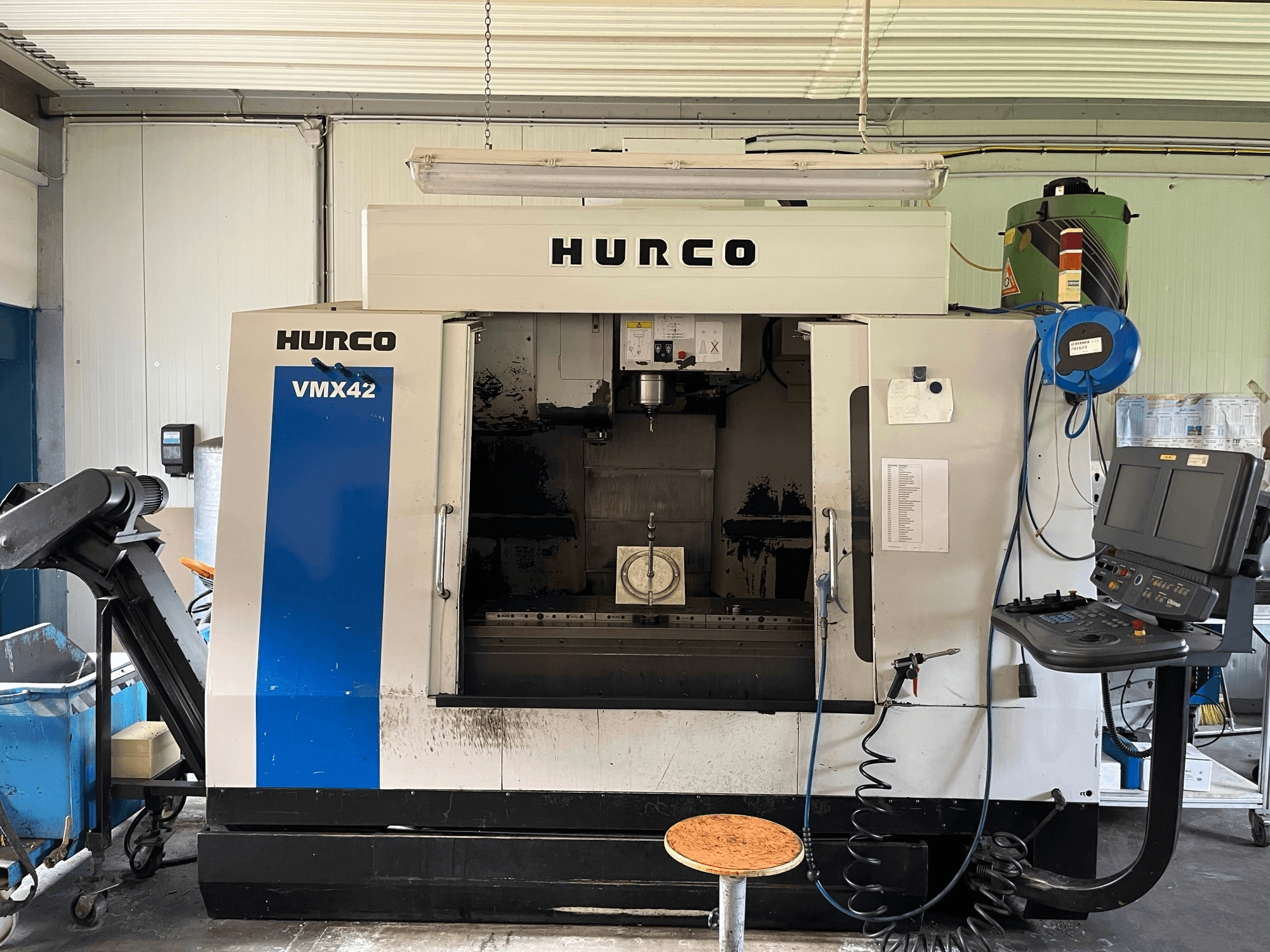 Hurco VMX 42 vertikaalne töötluskeskus külgvaates, kus on näidatud juhtpaneel, spindel ja tooriku seadistus.