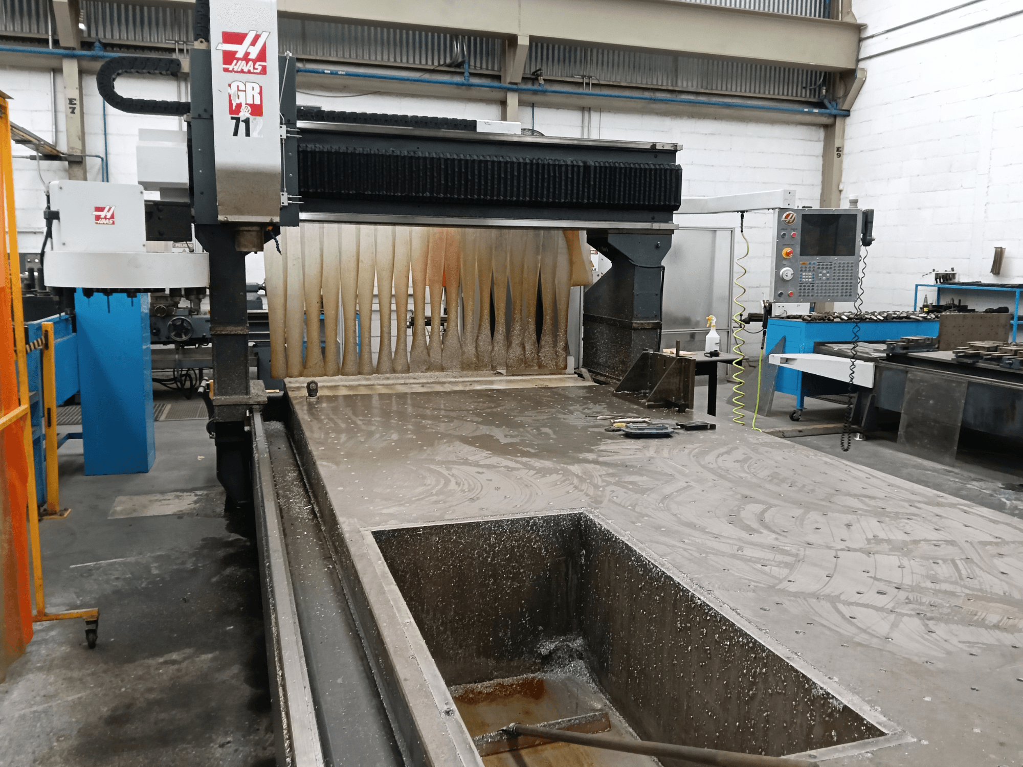 HAAS GR-712 portaalfreesmasin vaadatuna eestpoolt, millel on näha märg lõikepind ja operaatori juhtpaneel.