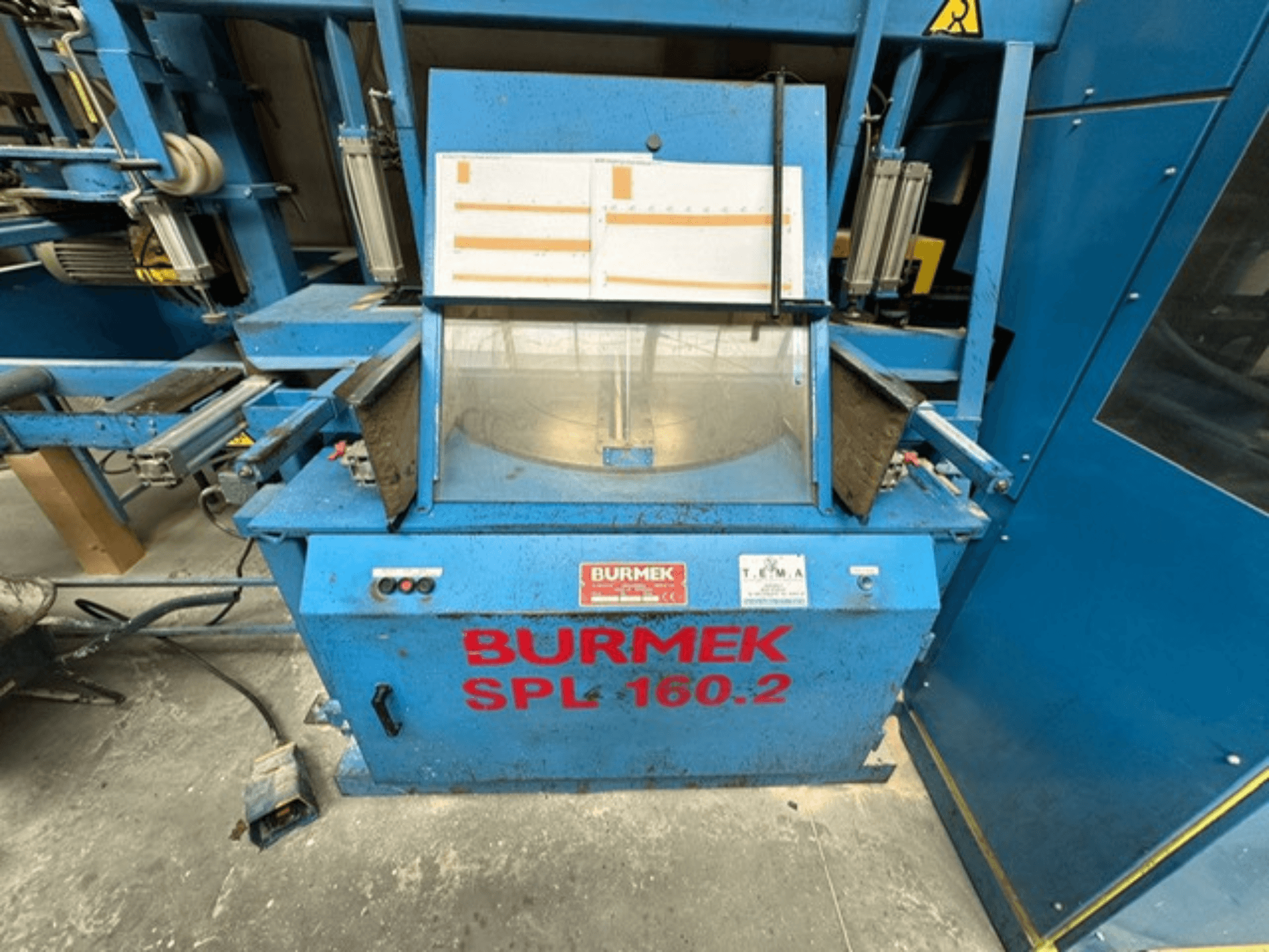 Sinine BURMEK SPL 160.2 puidumasin, esivaade, millel on juhtnupud ja klaasist paneel, mis näitab sisemust.